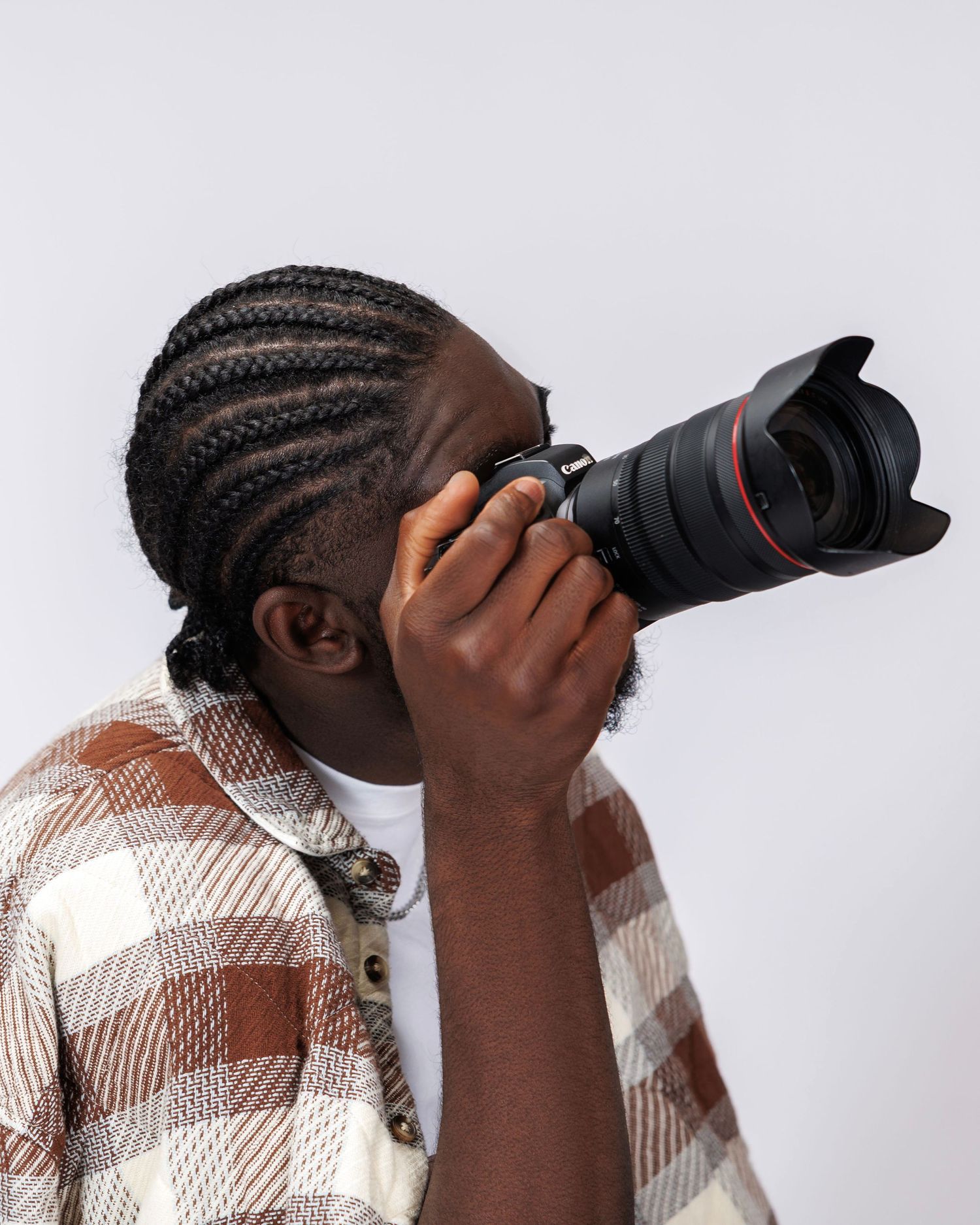 Side profile views examining camera while wearing plaid shirt against white background.