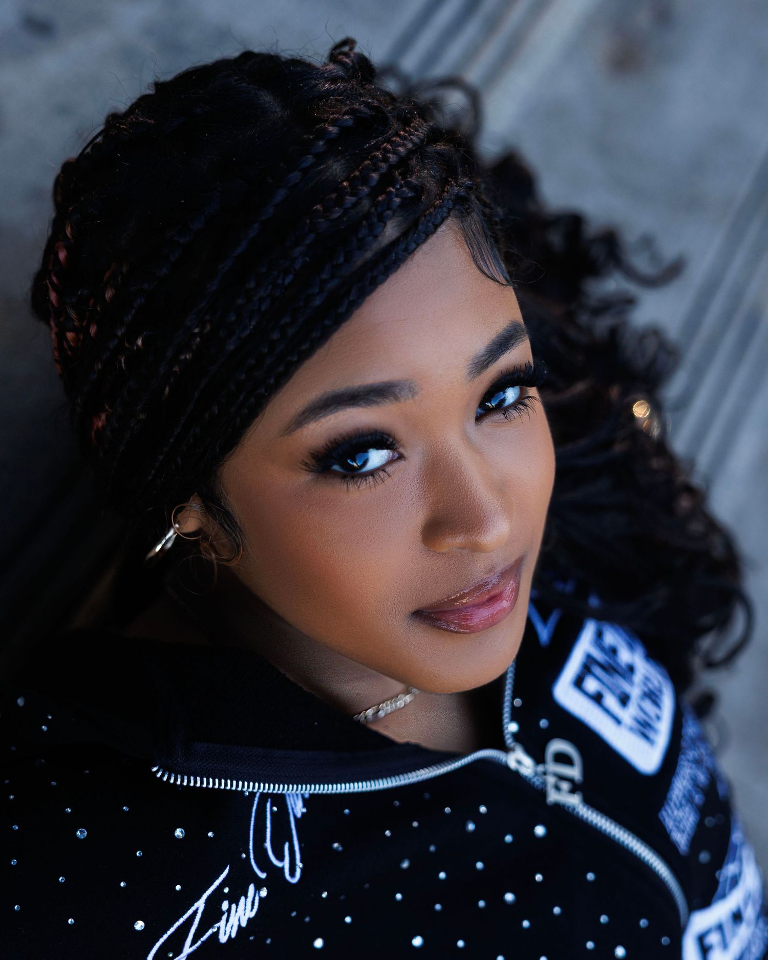 Close-up fashion portrait with sparkly black outfit and dramatic lighting.