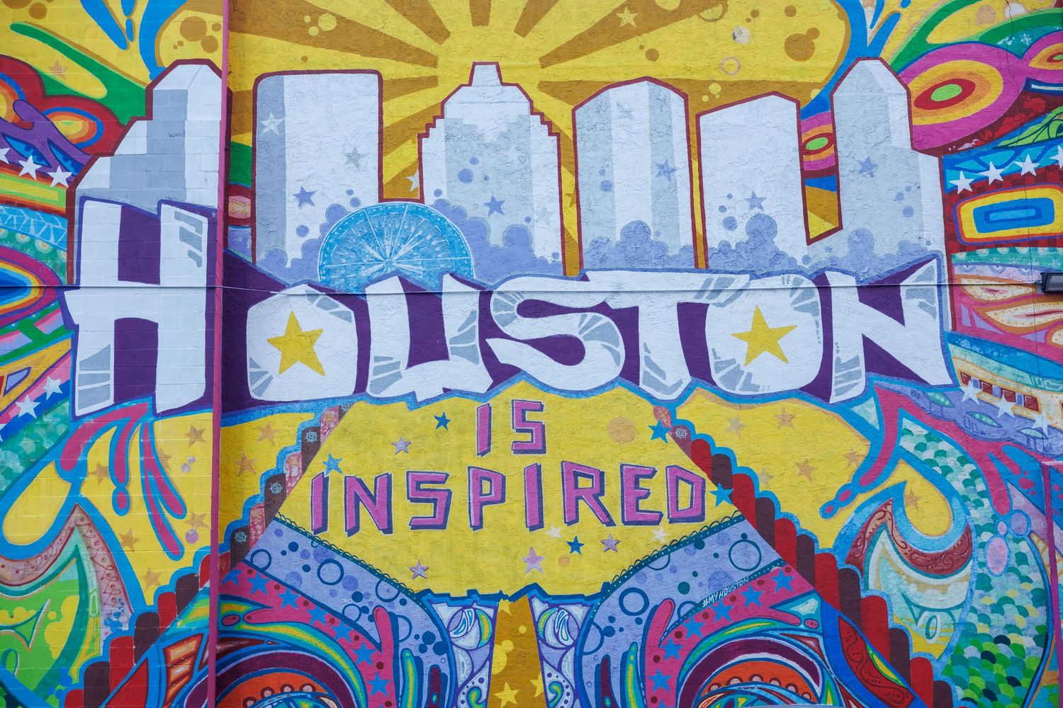 Colorful street art mural with inspirational text and vibrant designs.