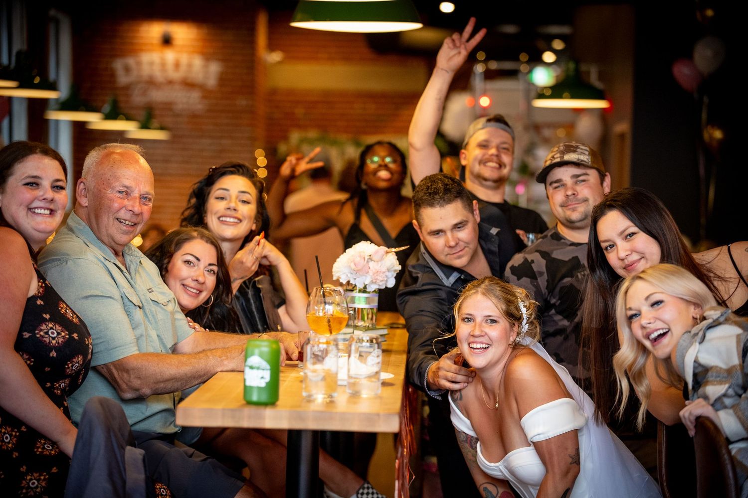 Group of friends laughing together while socializing at a dimly lit bar or restaurant.