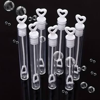 Clear glass test tubes with heart-shaped decorations and bubbles floating against a dark background.