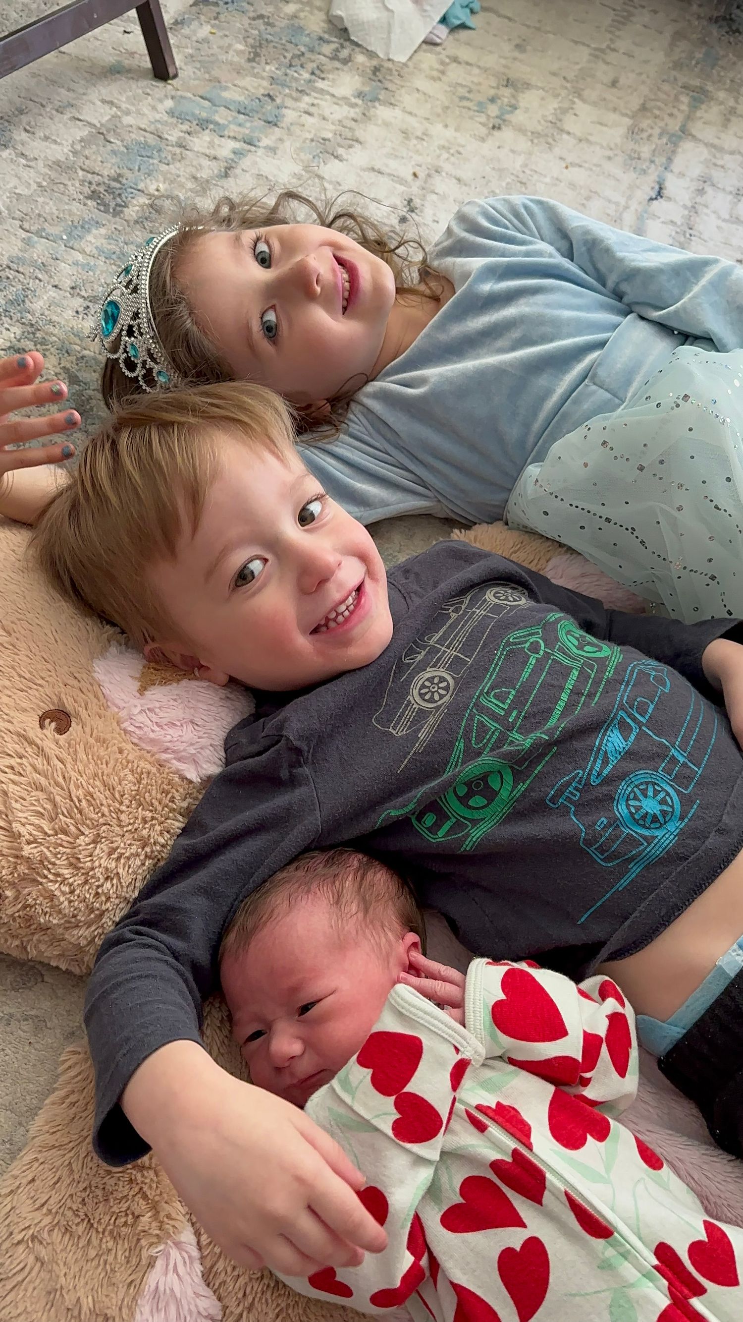 three kids laying on a floor