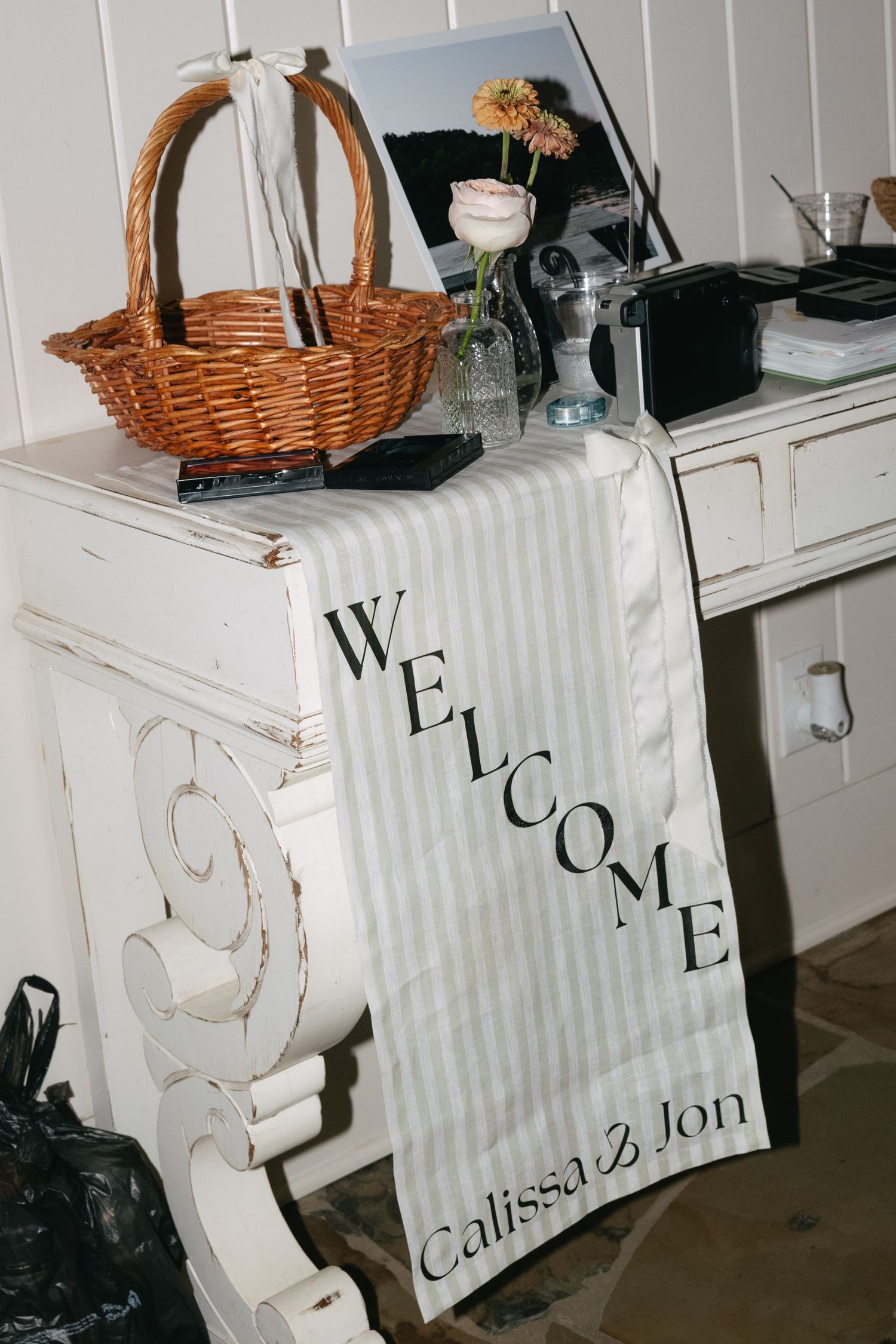White decorative welcome signs with elegant text displayed on wooden furniture.