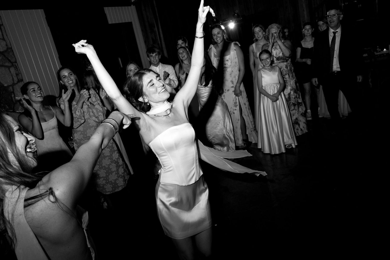 Black and white photos capturing energetic dancing and celebration at a wedding reception.