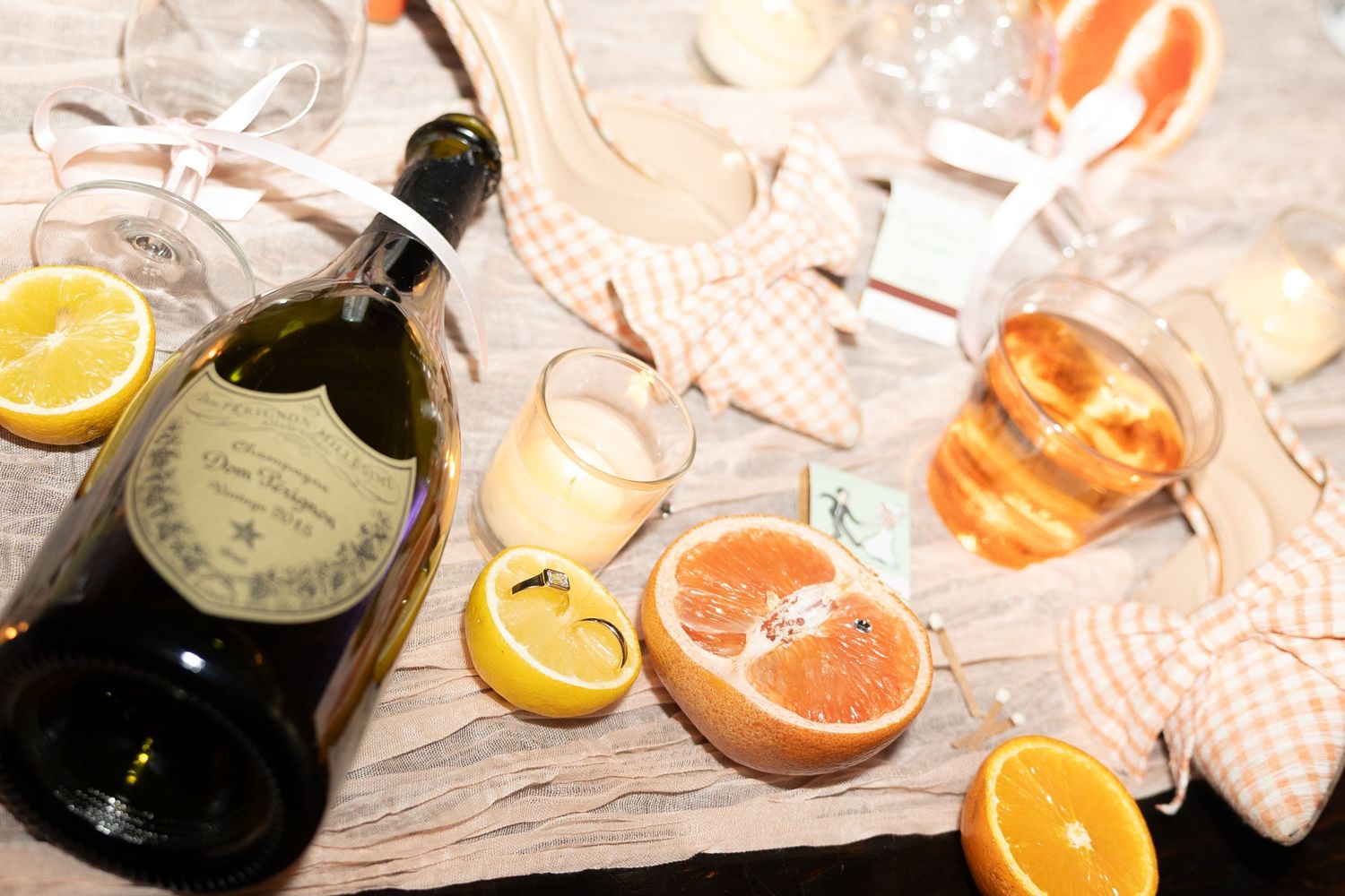 Citrus fruits and bottles arranged artistically on a textured surface.