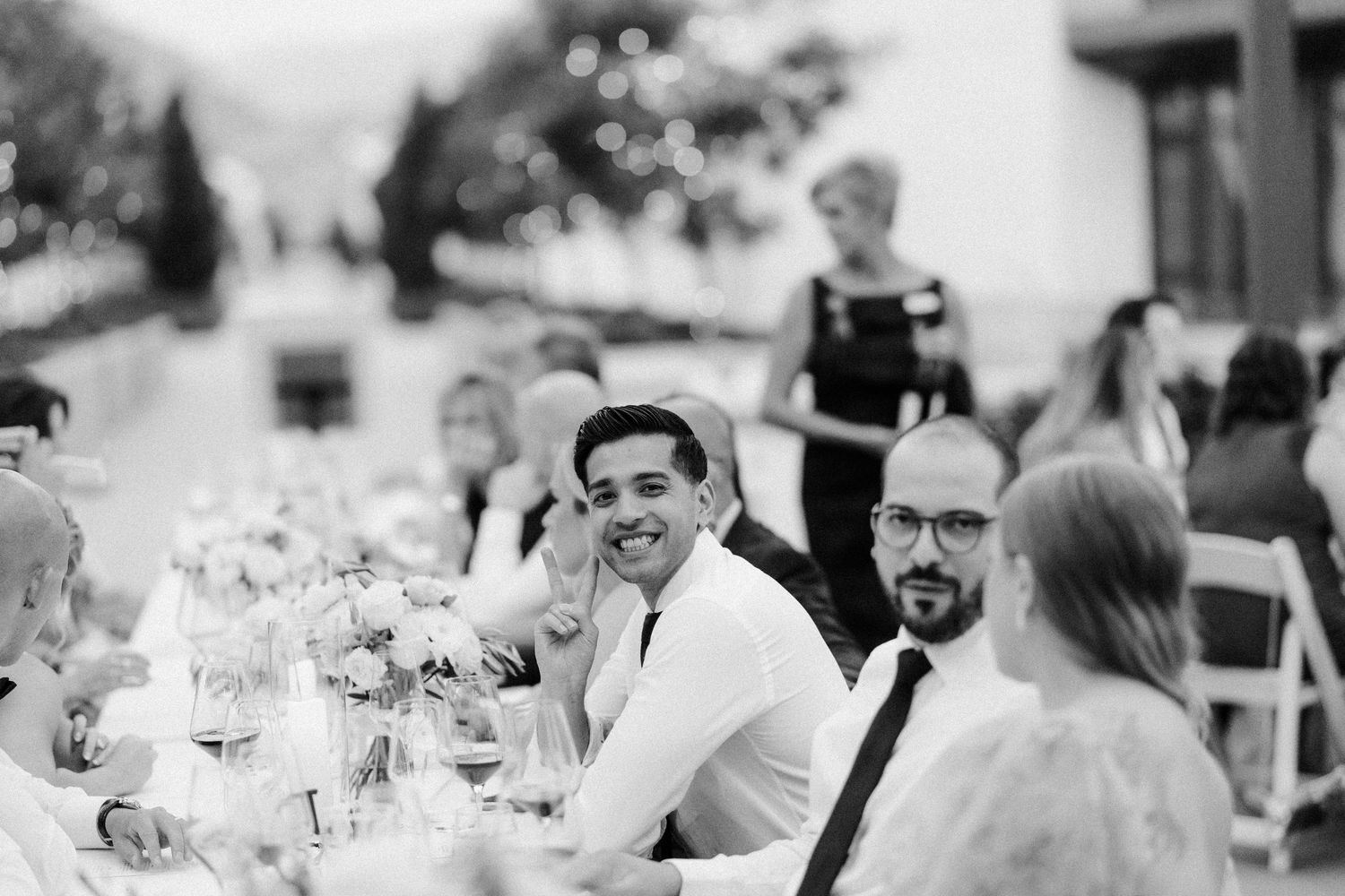 Black and white photo of guests enjoying an outdoor reception dinner.
