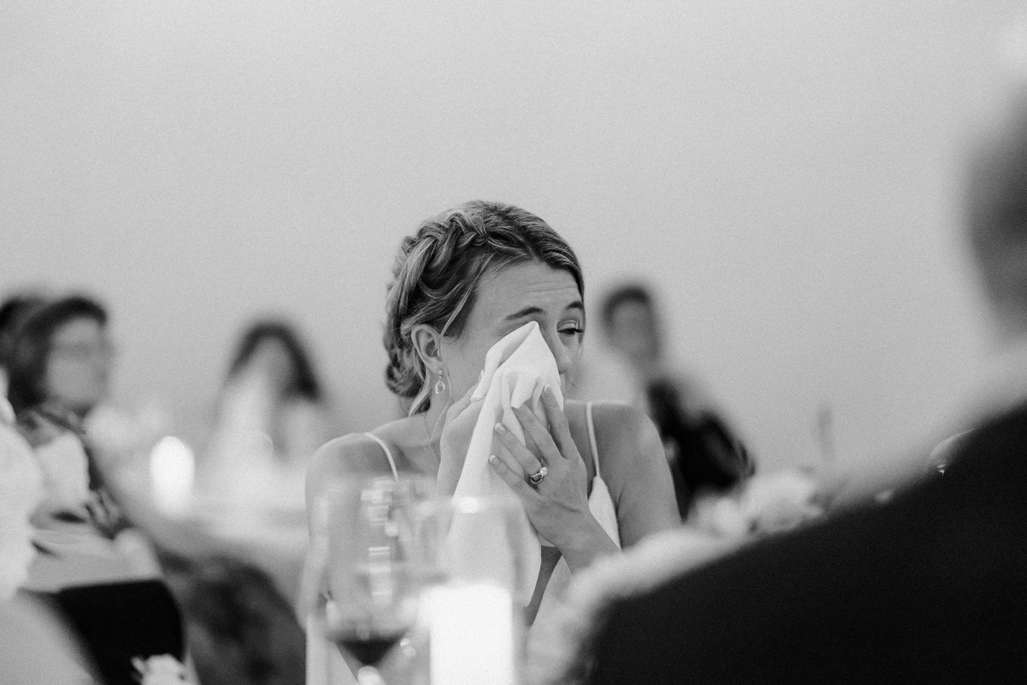 Candid emotional moment captured during wedding reception speeches.
