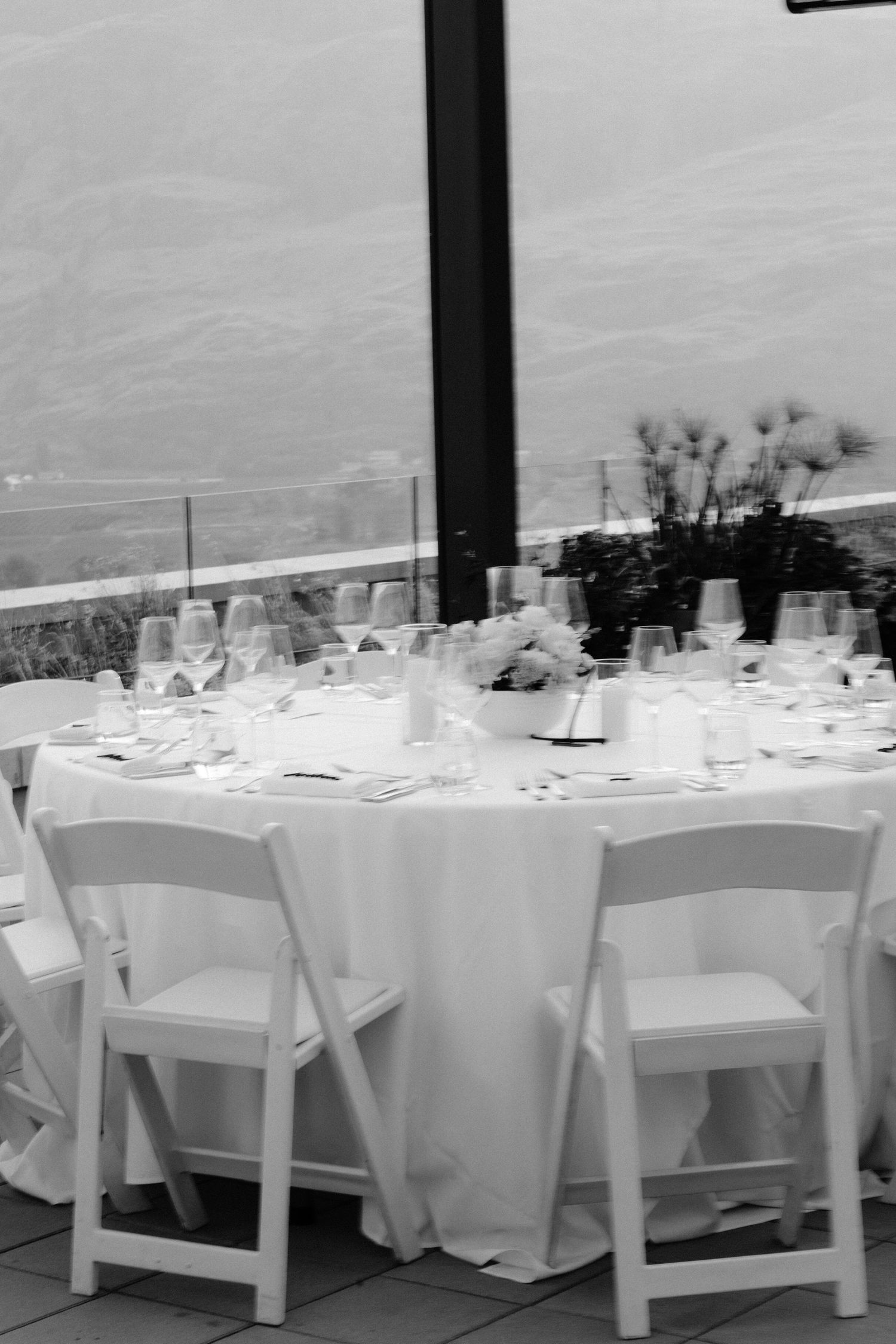 An elegant white wedding reception table setting with mountain views in the background.