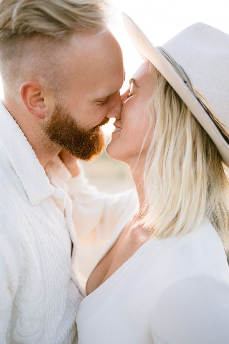 Intimate close-up portrait of a couple sharing a tender moment in the desert light.