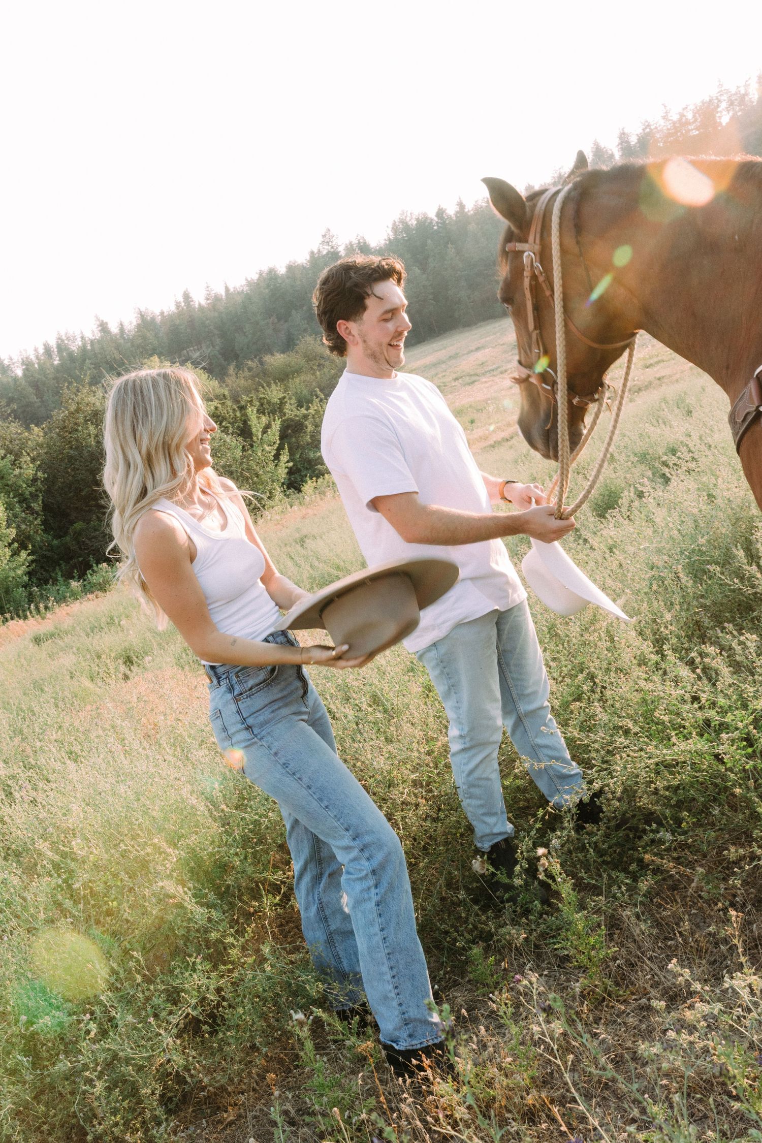 Candid moments between people and horses in a sunny meadow with wildflowers.