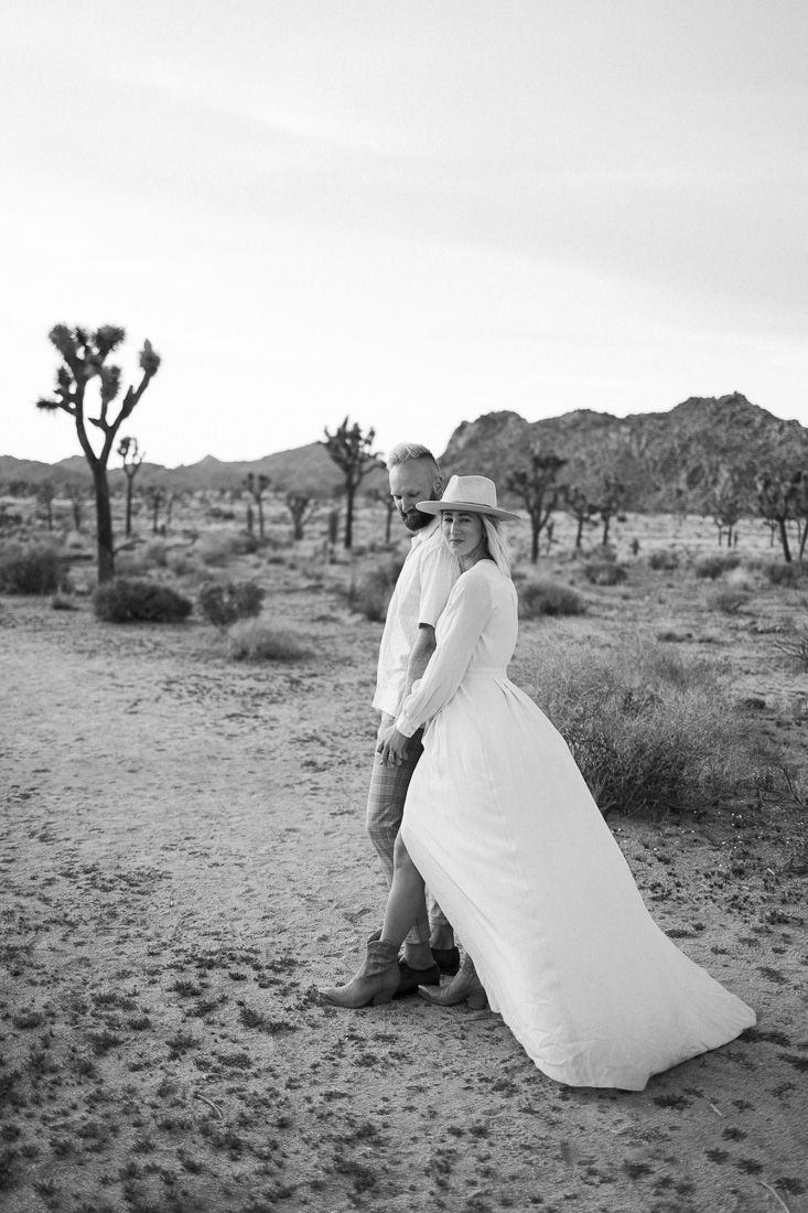 Black and white desert portrait with Joshua trees and mountains creating a dramatic backdrop.