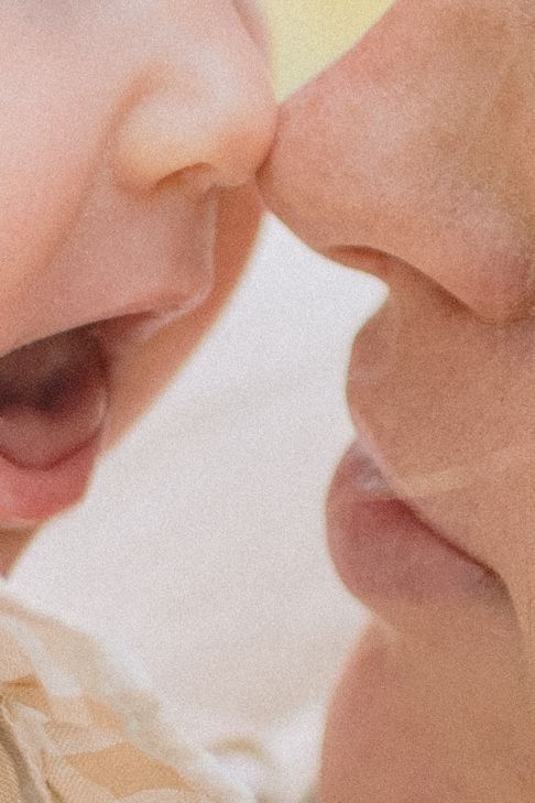An intimate close-up shot of two lips nearly touching in a loving moment against a soft, dreamy background.