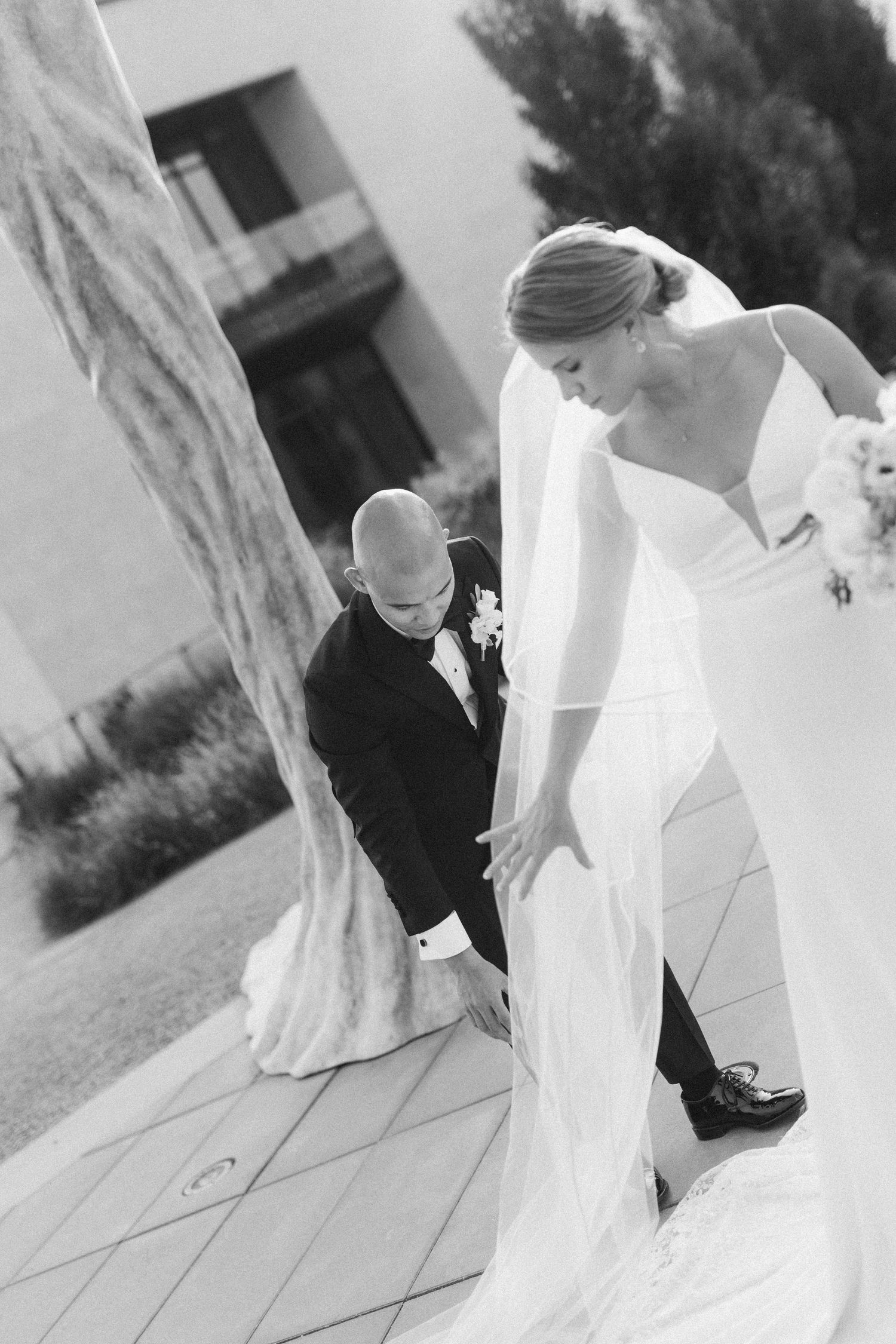 Black and white wedding photo capturing an elegant moment on an outdoor terrace.