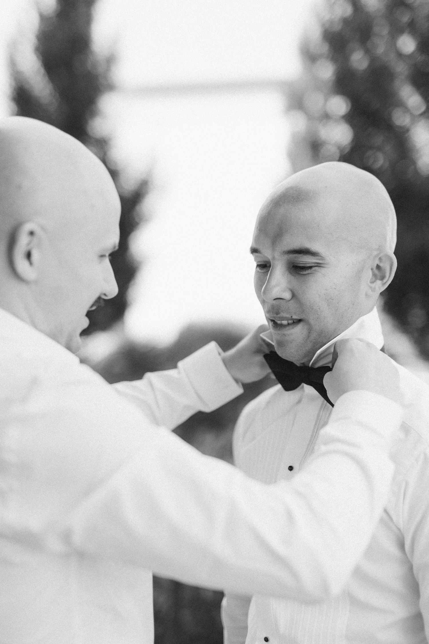 Two people in formal attire share an intimate moment during a wedding ceremony.