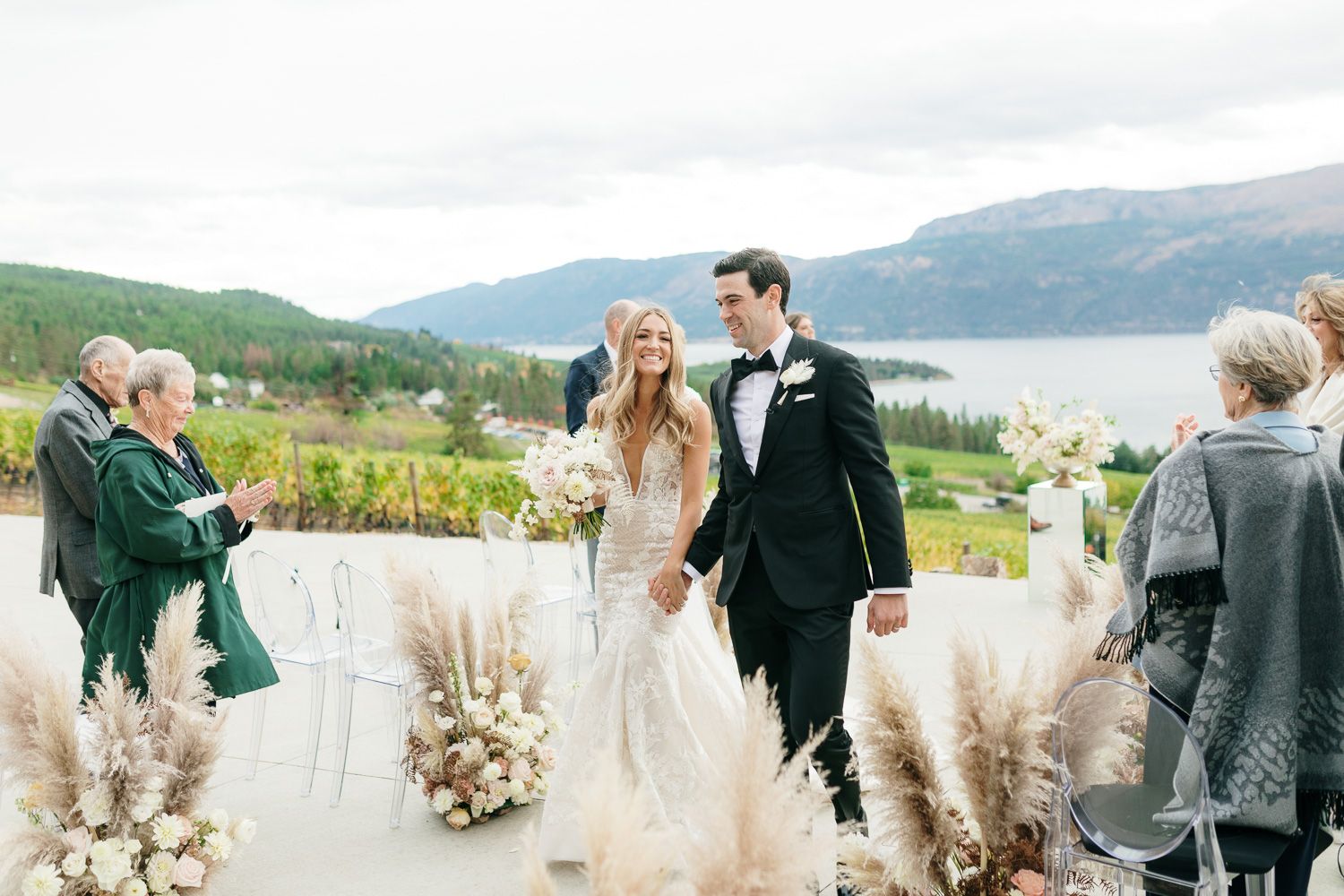 Wedding ceremony on a scenic overlook with pampas grass decor and mountain views.
