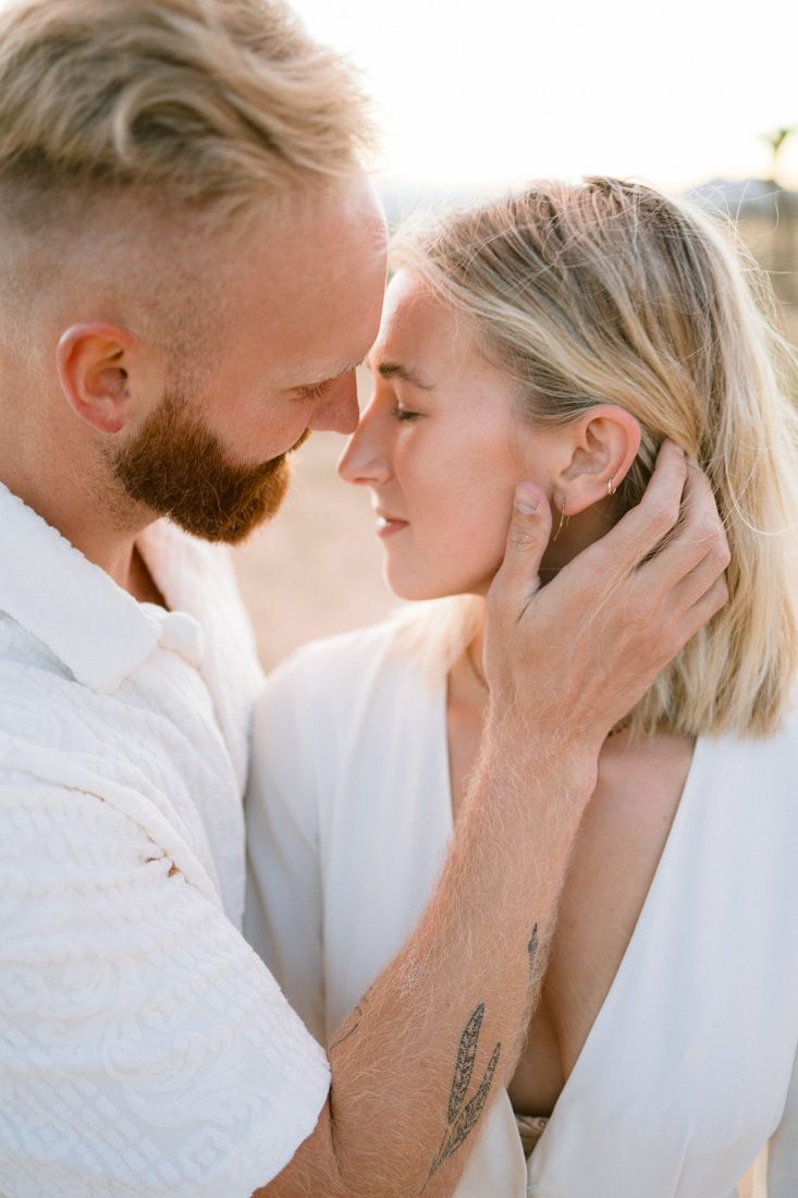 An intimate close-up of a couple sharing a tender moment in warm sunset light.