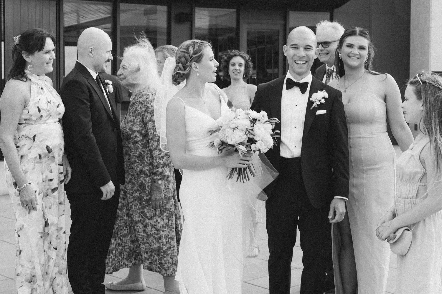 Wedding guests and family members posing for formal group photos outside.