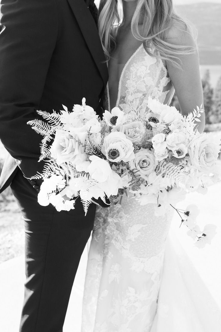 Black and white detail shot of wedding bouquet with roses and ferns.