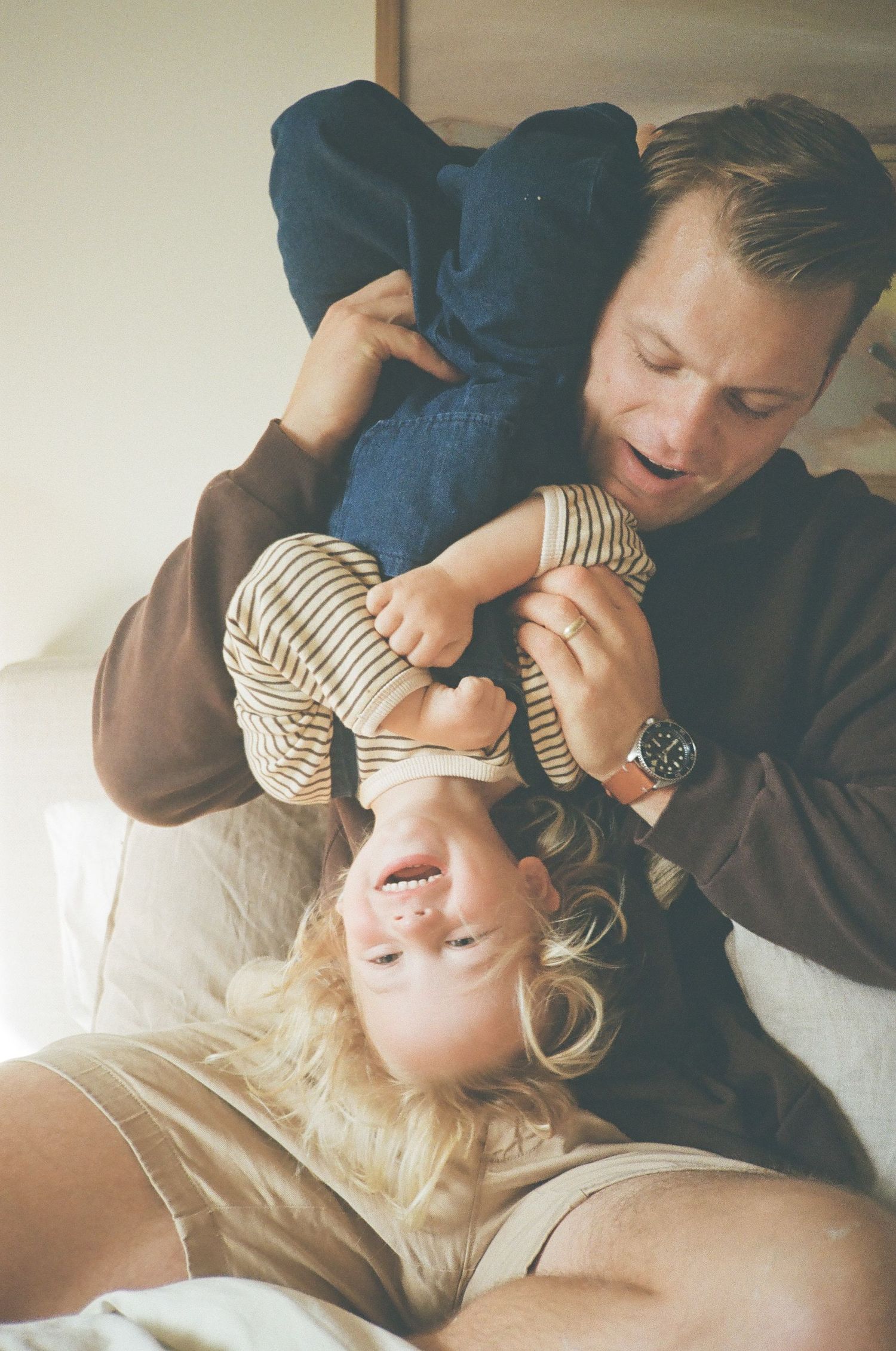 Sweet candid moment of playful interaction between parent and toddler while relaxing at home together.