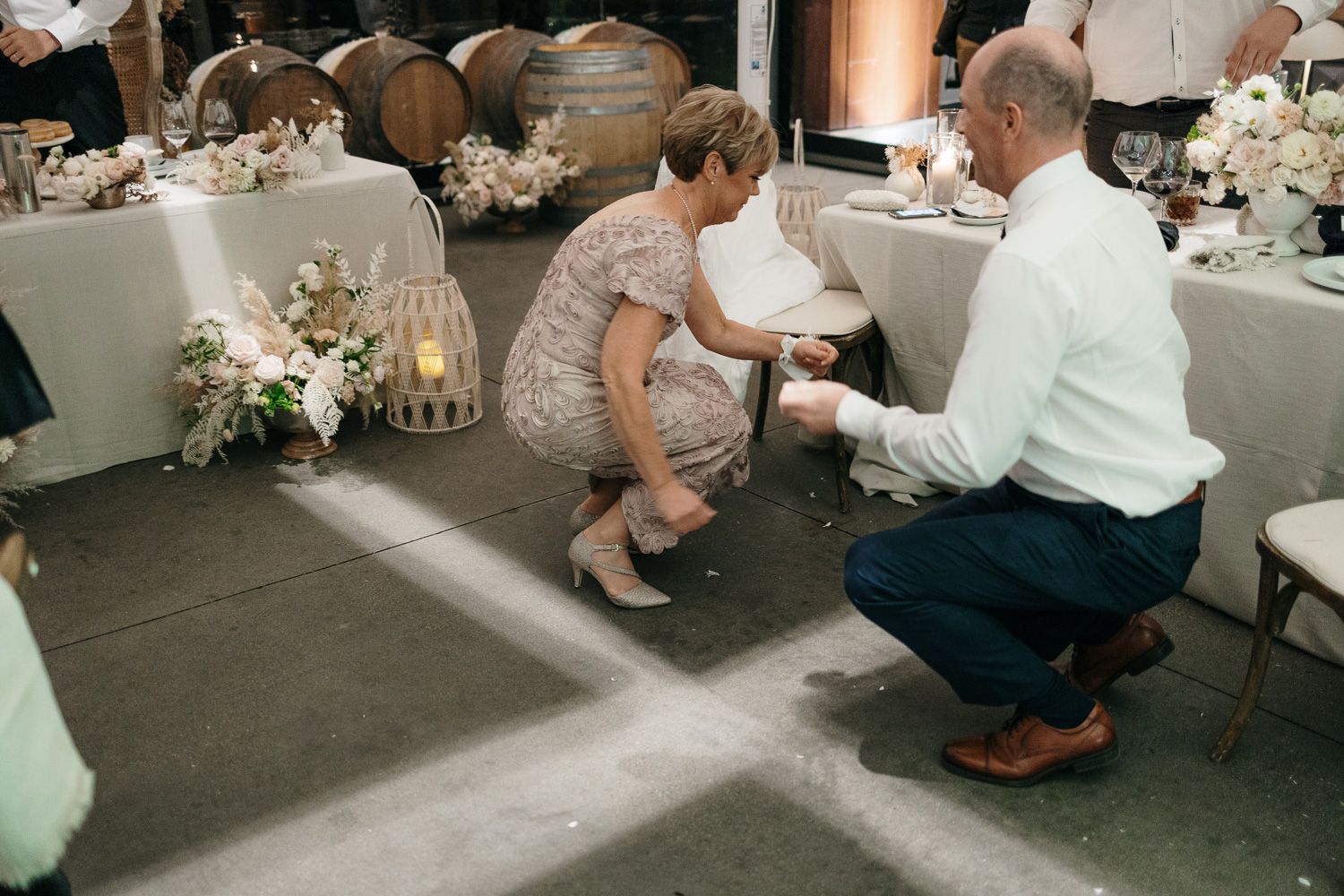 Wedding guests interact on dance floor during reception celebration.