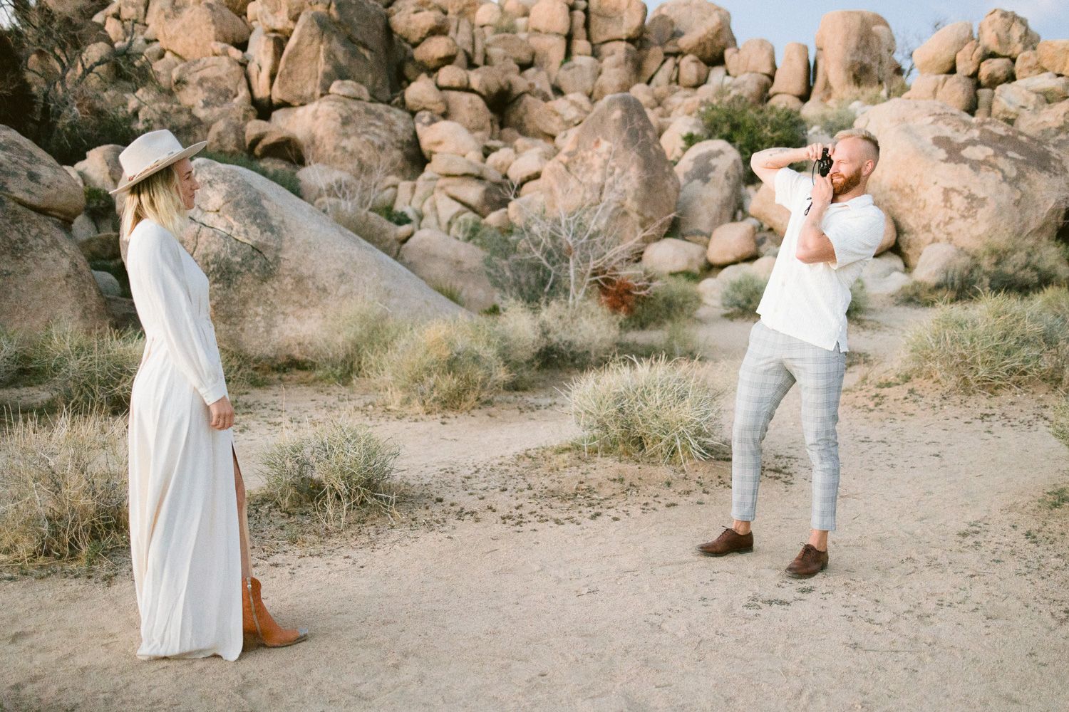 Playful desert photo session with two people taking pictures of each other.