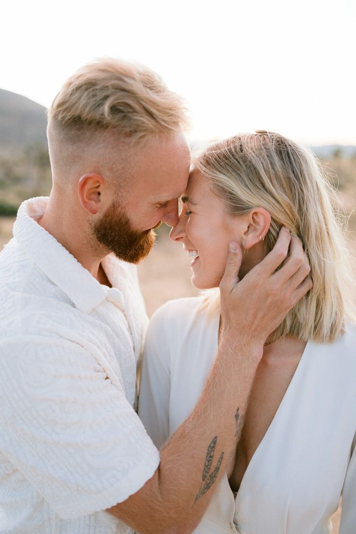 A close-up portrait of a couple sharing a tender moment in natural light.
