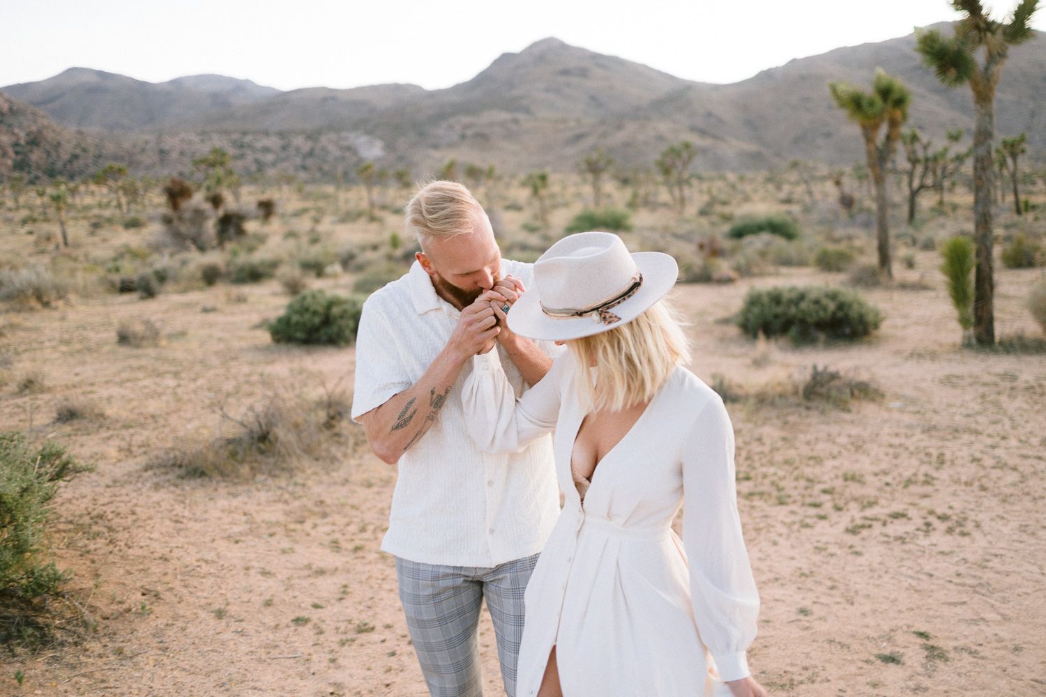 A candid desert photoshoot with Joshua trees and mountain scenery.