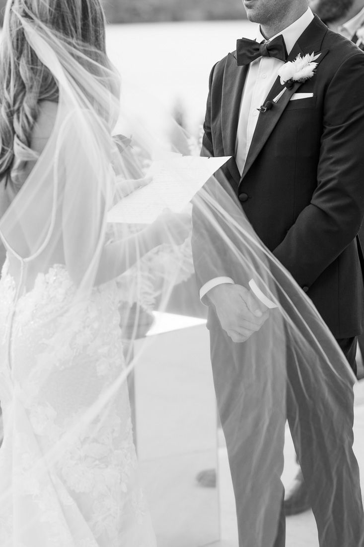 A black and white detail shot of wedding attire during an outdoor ceremony.