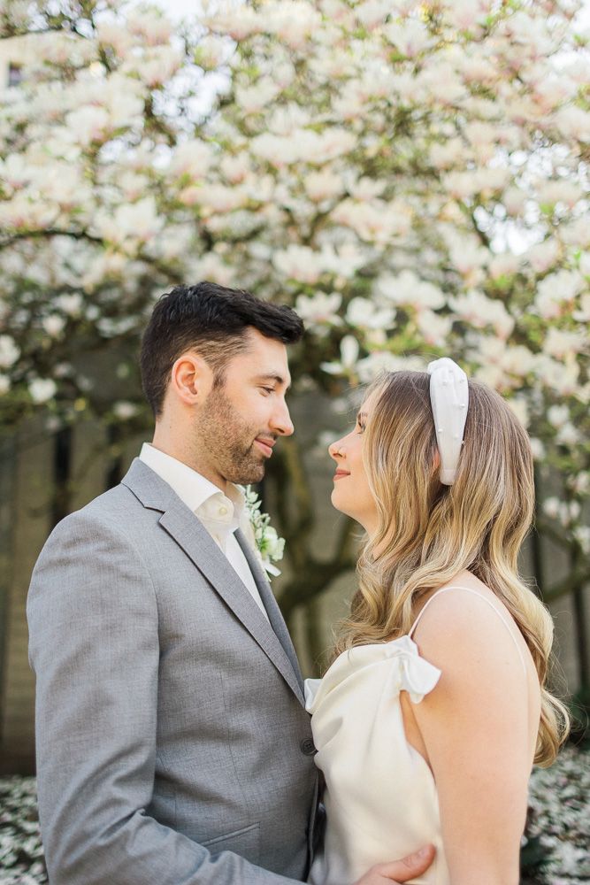 Tender moment between couple under flowering cherry blossoms.