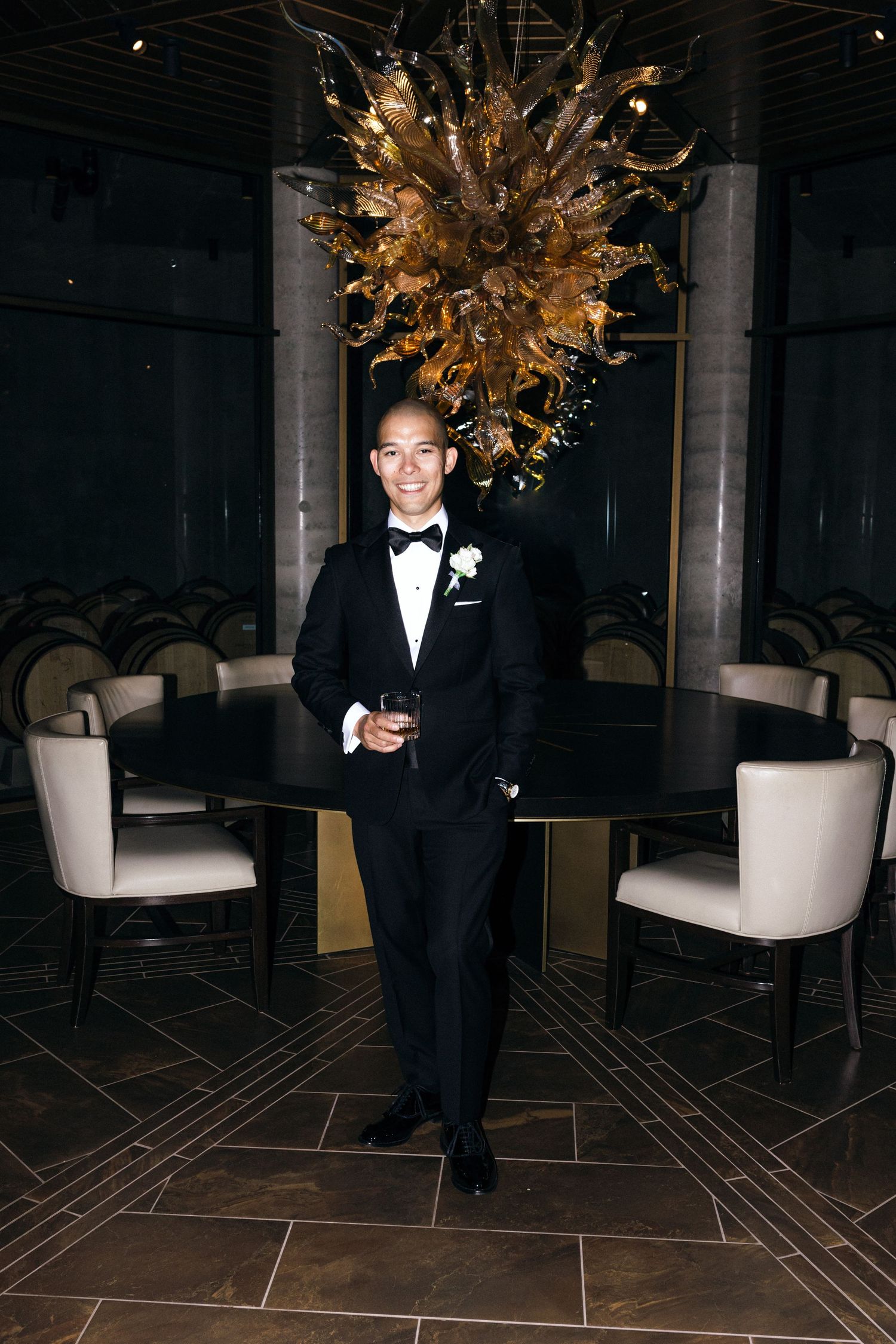 Elegant formal event space with a striking gold chandelier and modern black and white decor.