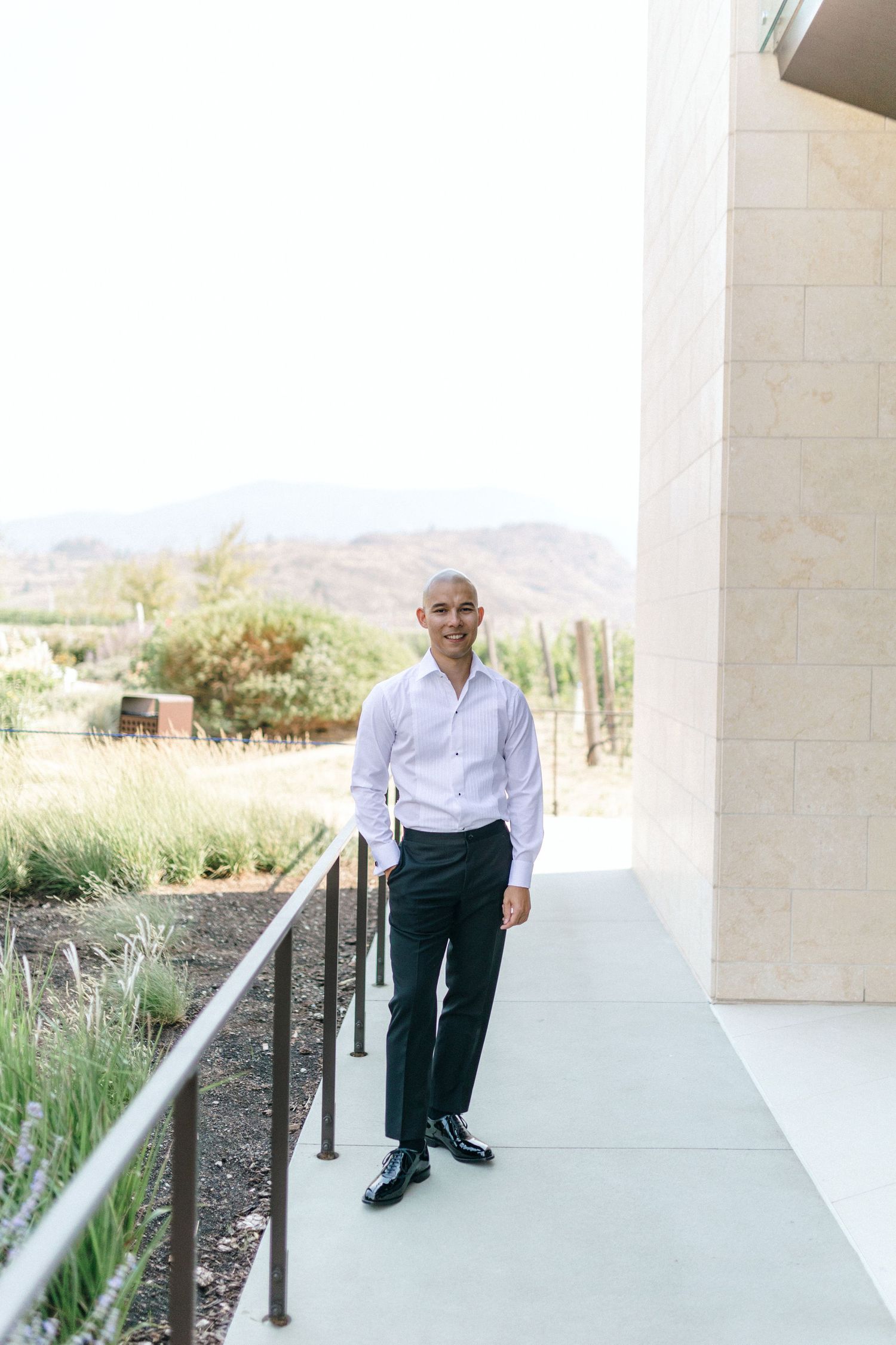 Modern outdoor walkway with white pillars and mountain views.
