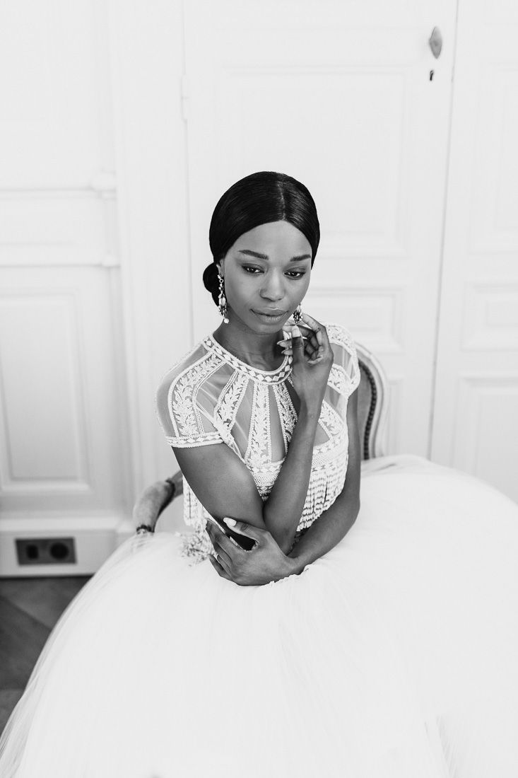 Close-up bridal portrait showcasing intricate beadwork on a tea-length wedding gown.