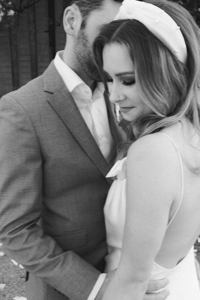 An intimate black and white wedding photo showing a tender moment between newlyweds.