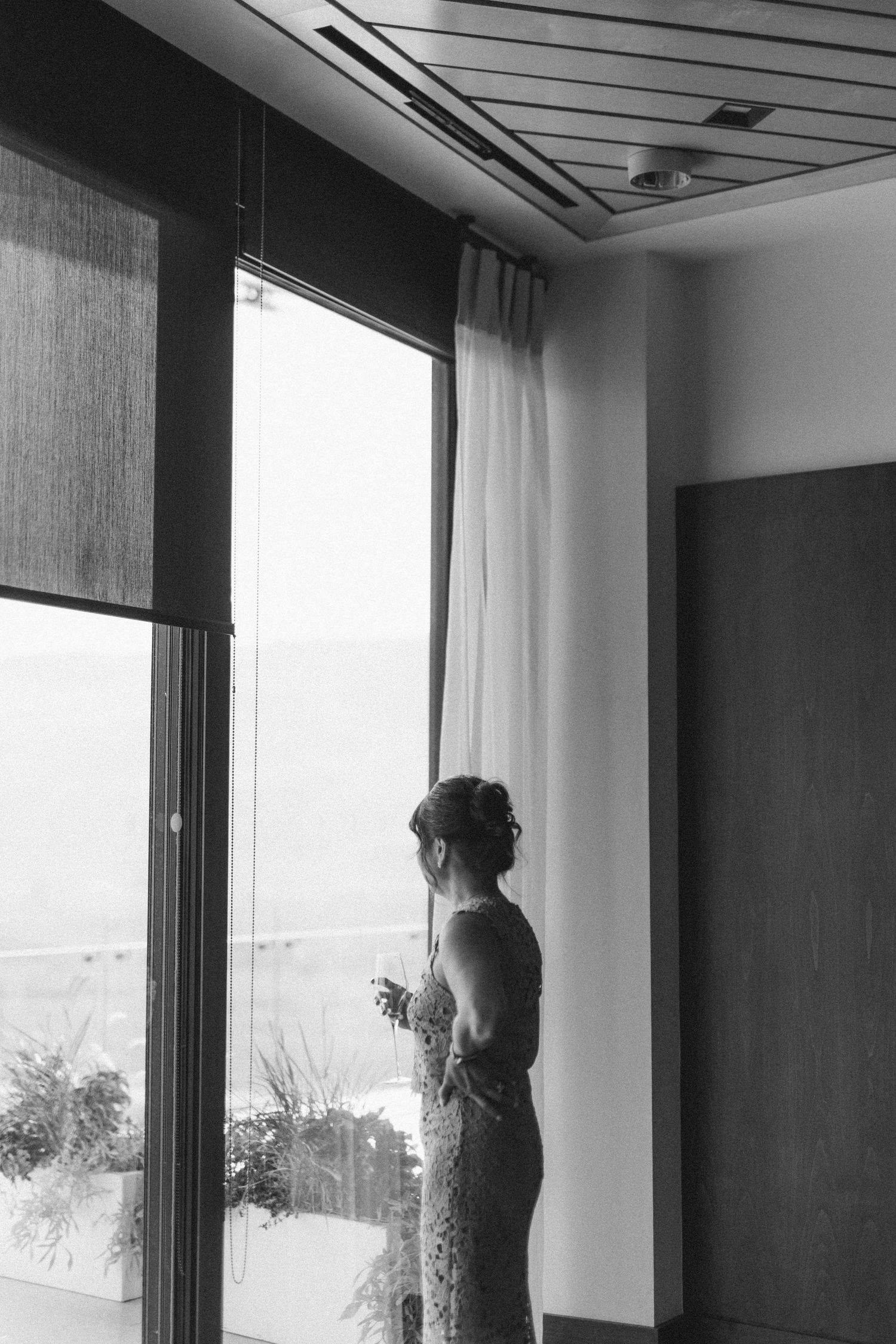 Silhouettes of wedding preparations against bright windows in a modern room.