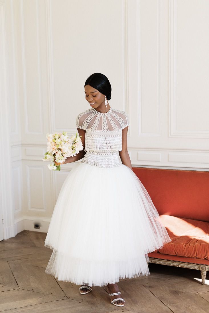 Elegant tea-length wedding dress with detailed bodice and tulle skirt captured in bright room.