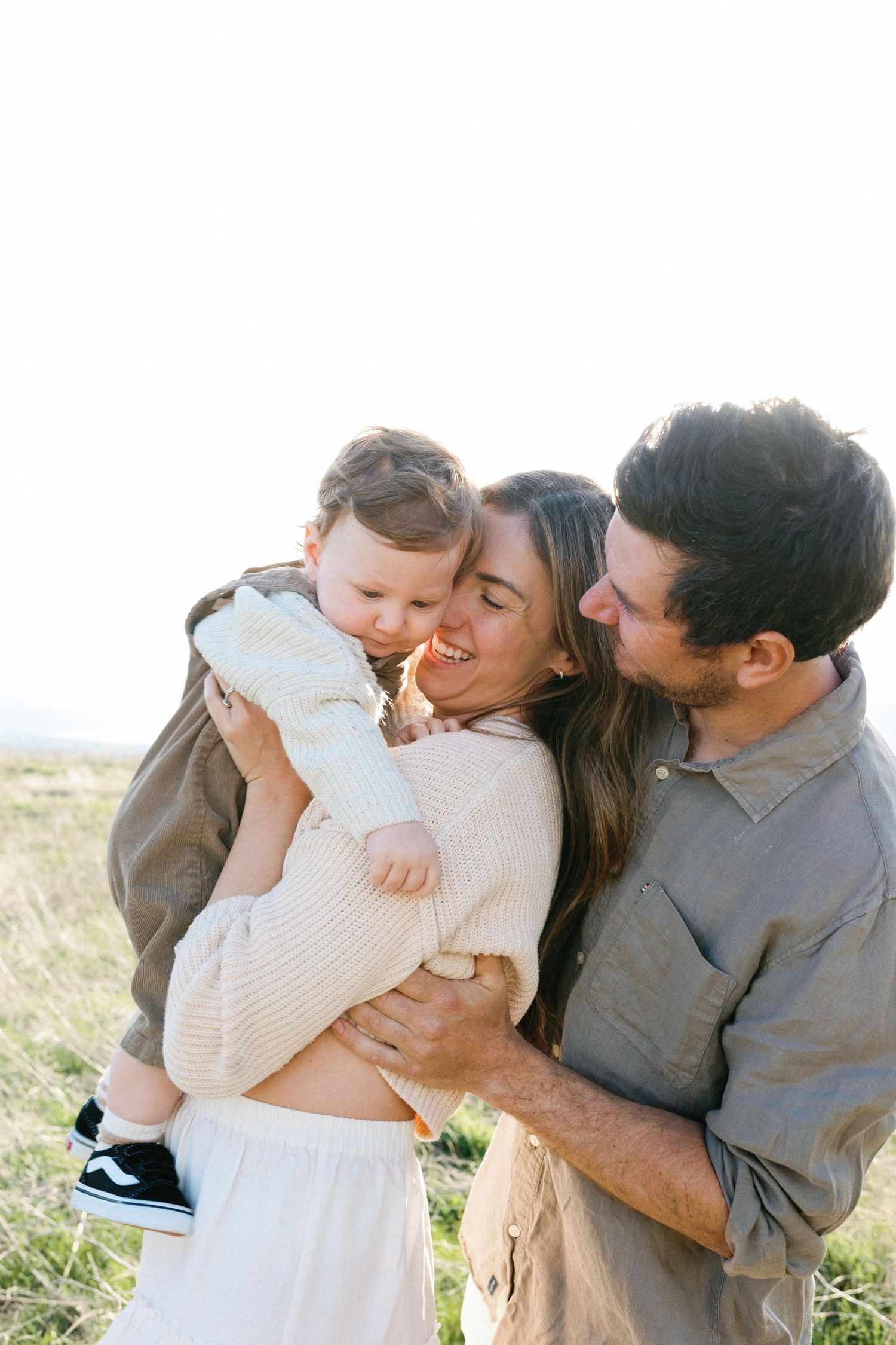 A series of intimate family photos showing tender moments of affection and love between parents and baby outdoors.