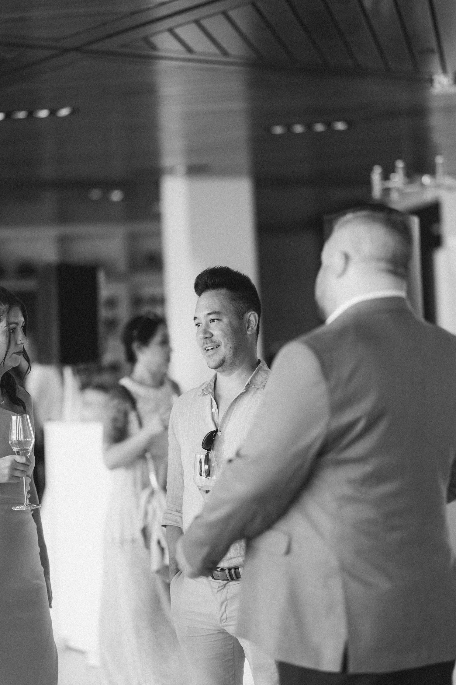 Wedding reception in black and white with guests mingling in an indoor venue.