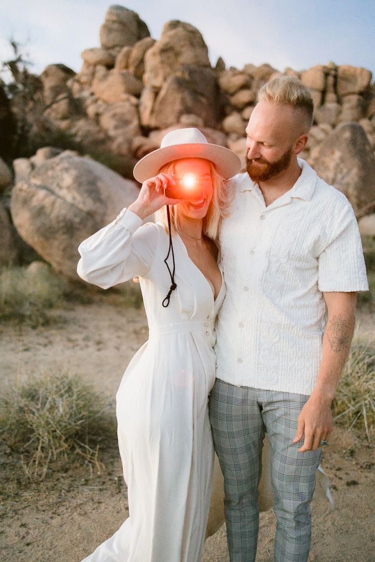 Sunset desert photoshoot with one person using a vintage flash camera.