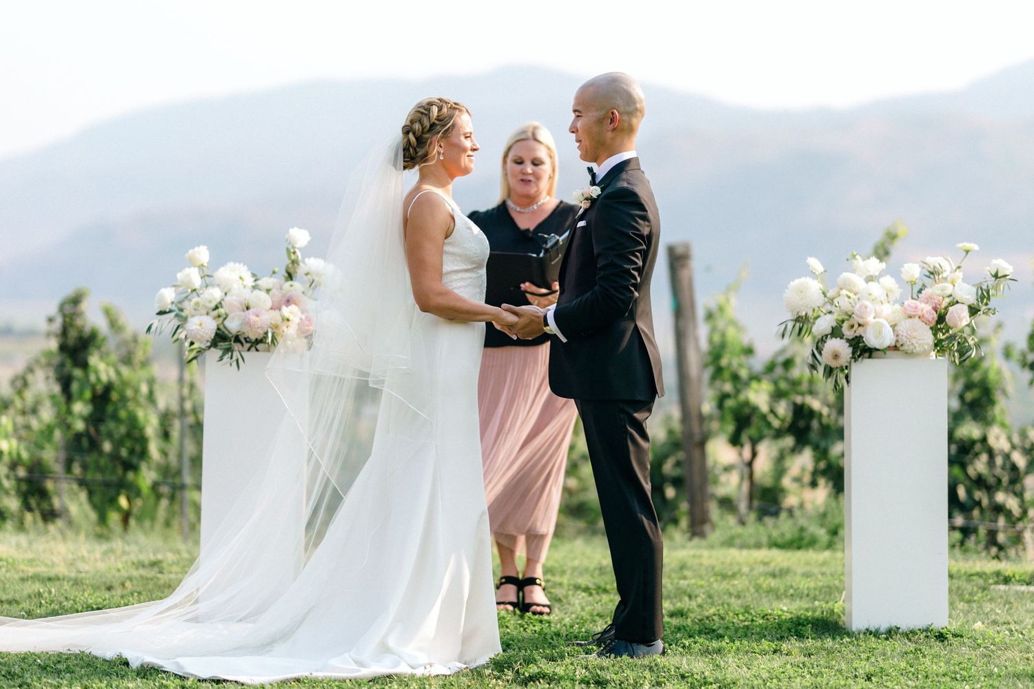 Outdoor wedding ceremony setup with floral arrangements and mountain views.