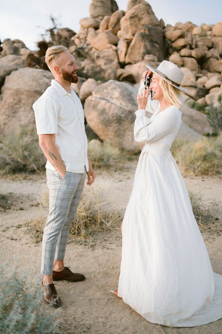 A romantic desert photoshoot with towering rock formations in the background.