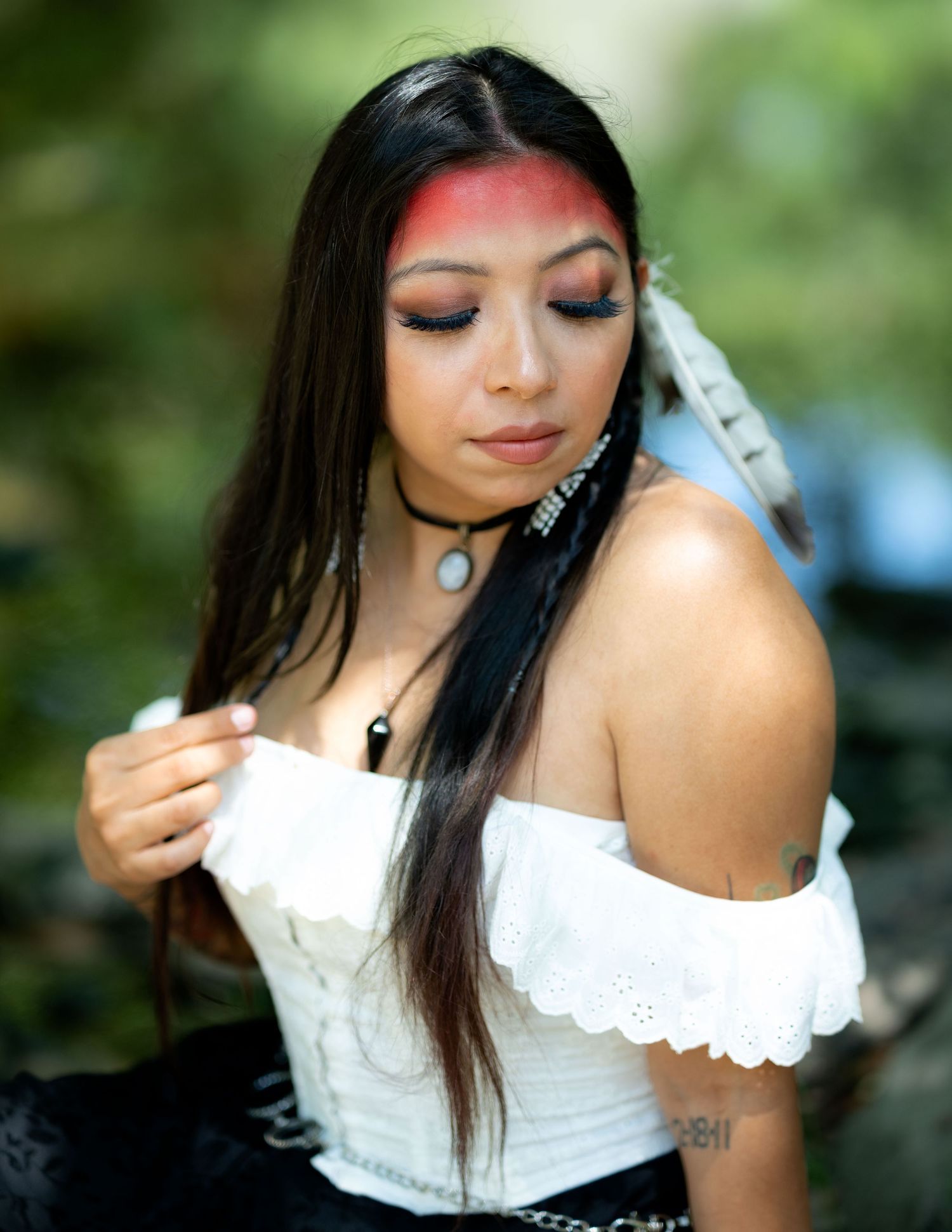 A series of artistic portrait photos showing a person in a white lace top against a blurred natural background.