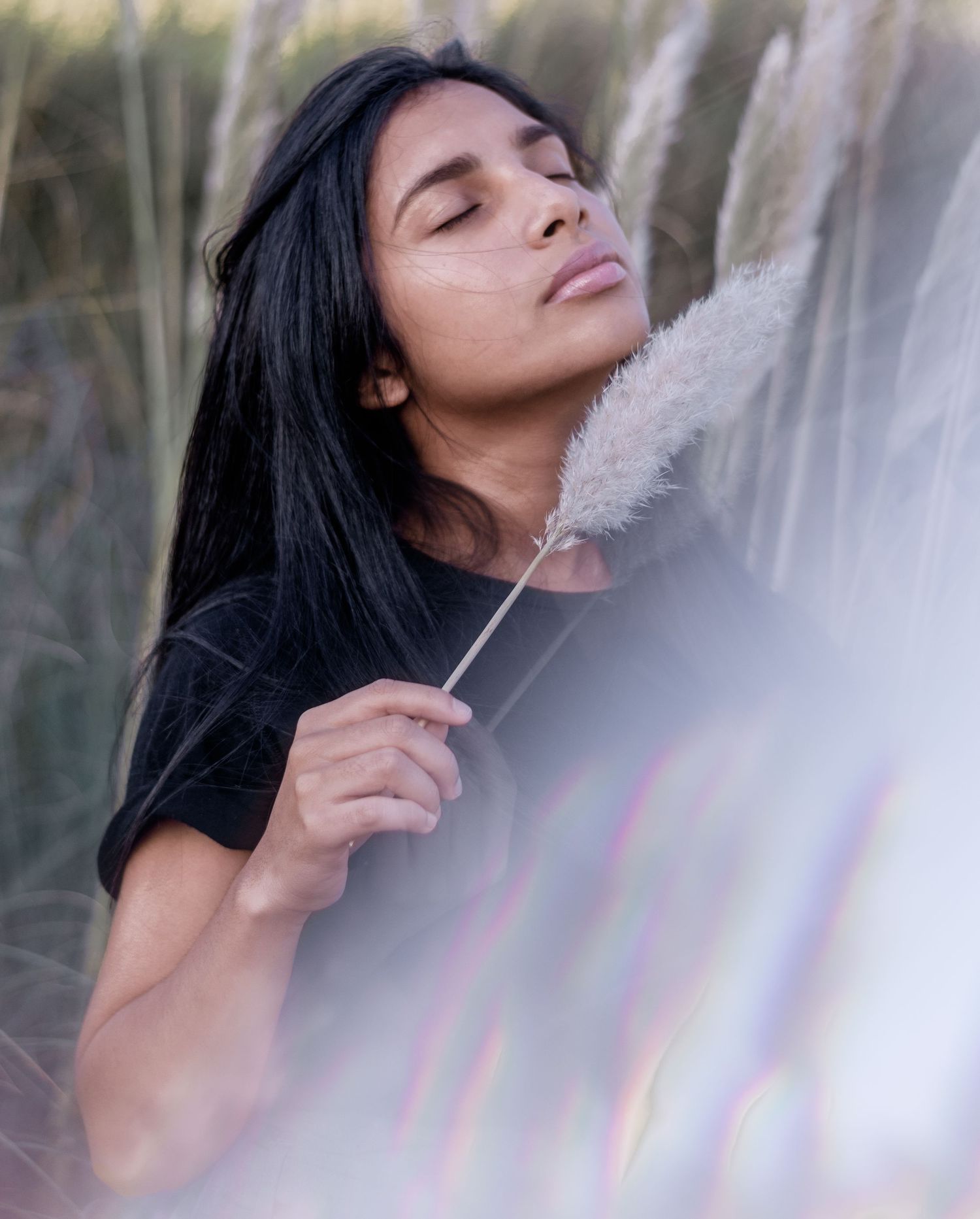 Künstlerisches Personal Branding Portrait einer Frau im hohen Gras, natürliche Outdoor-Fotografie für Kreative in Chur.