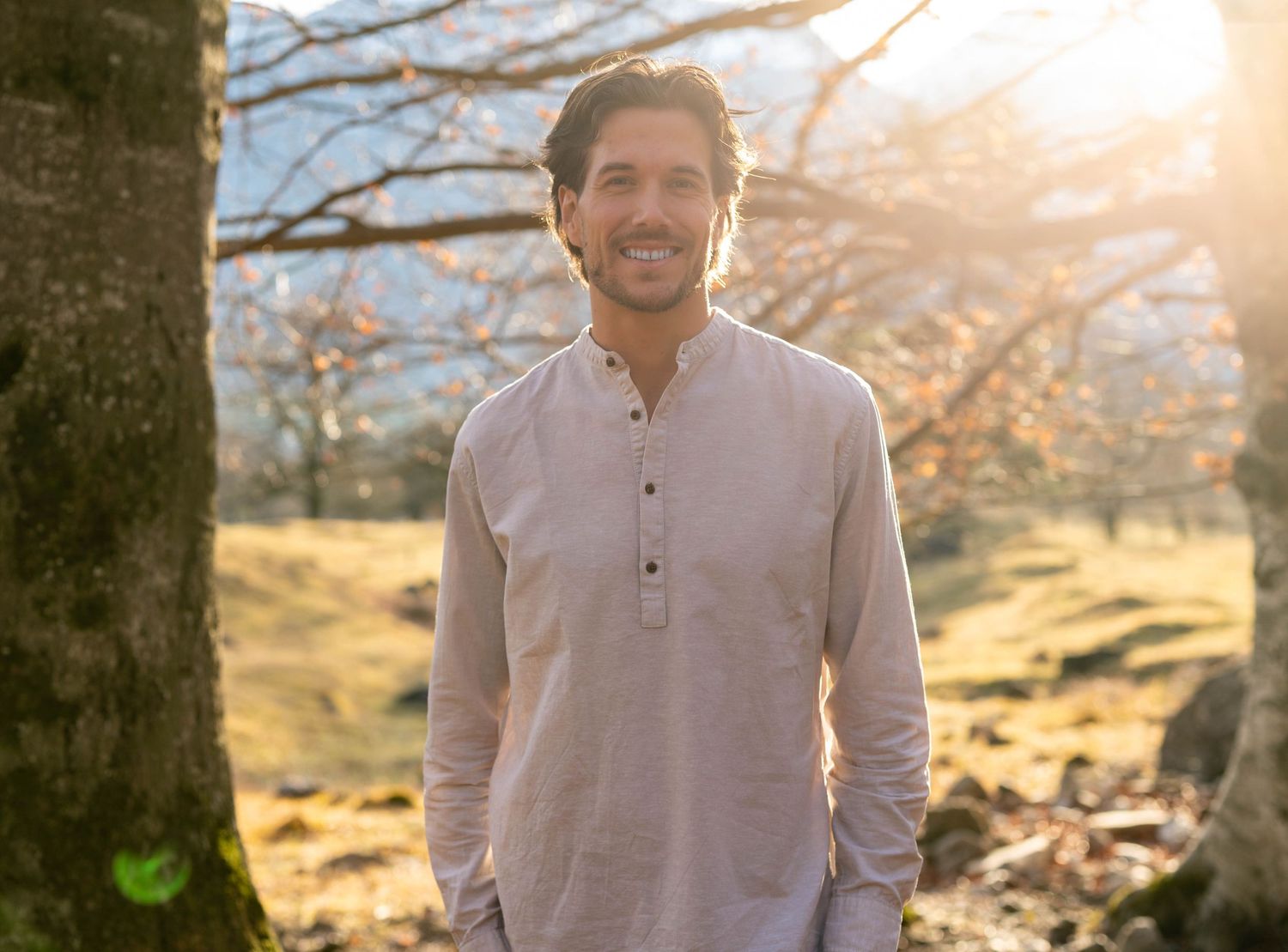 Sympathisches Outdoor-Portrait eines Naturheilpraktikers im Wald, Personal Branding für ganzheitliche Medizin nahe Davos.