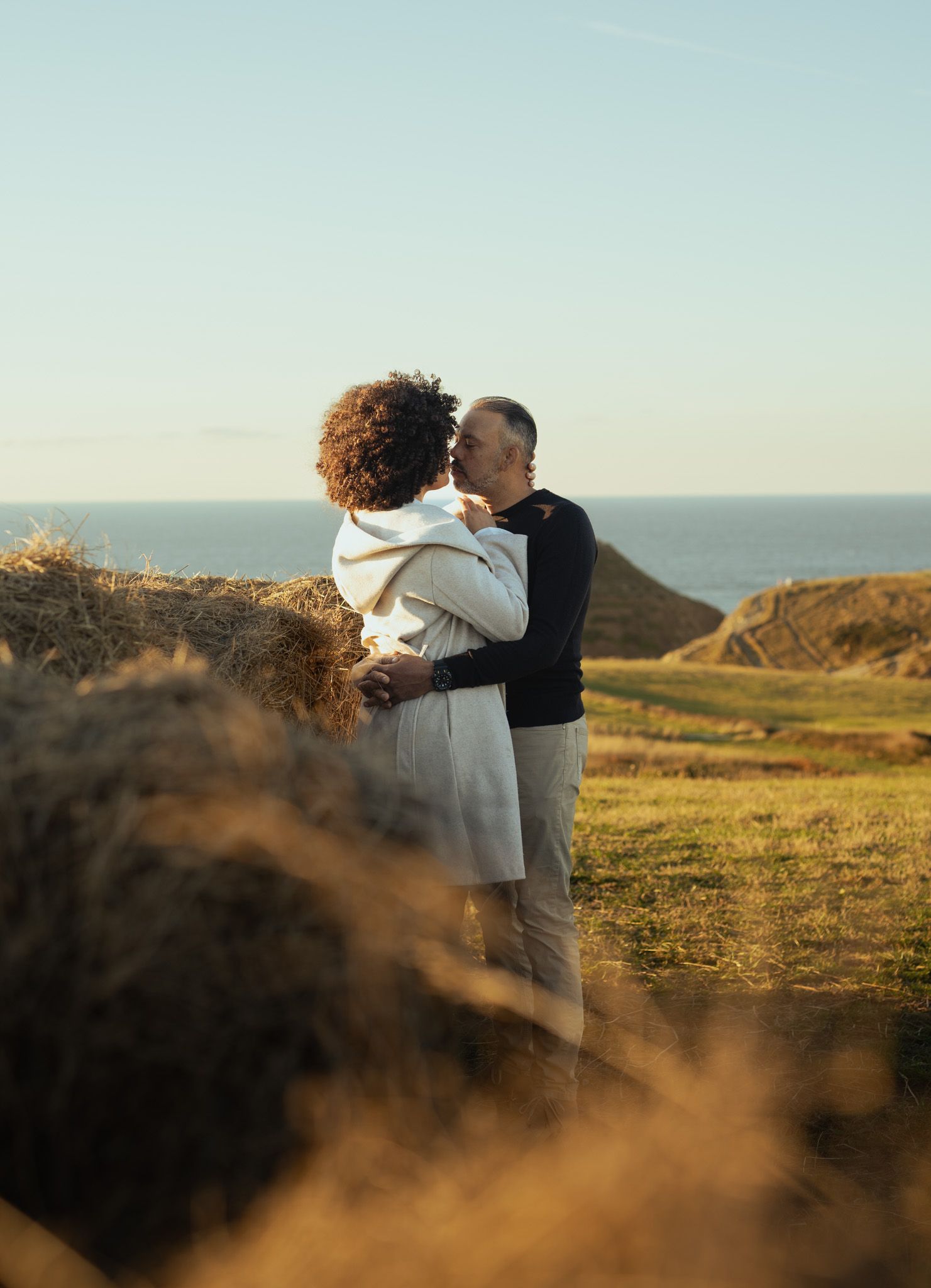 Intimes und romantisches Paarshooting im hohen Gras im Bohemian-Stil während der goldenen Stunde in Nature