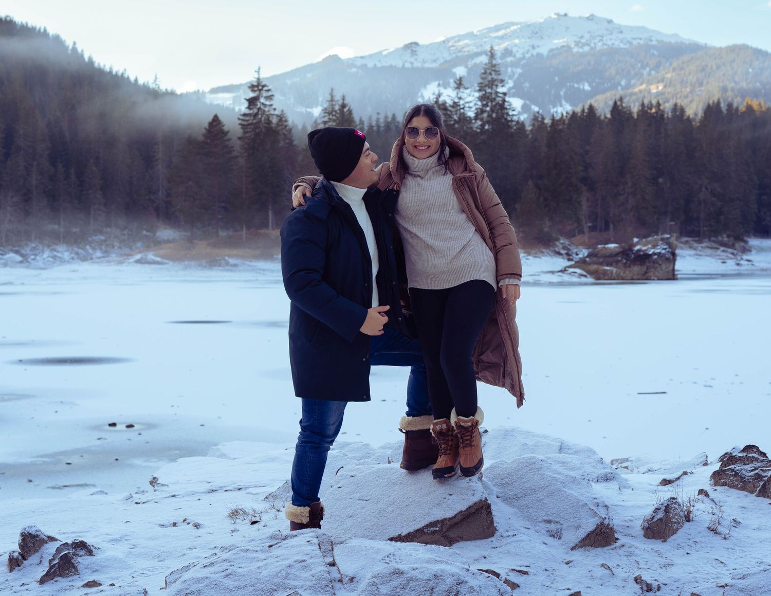 Romantisches Paarportrait im Schnee an einem gefrorenen See, winterliches Paarshooting in Caumasee