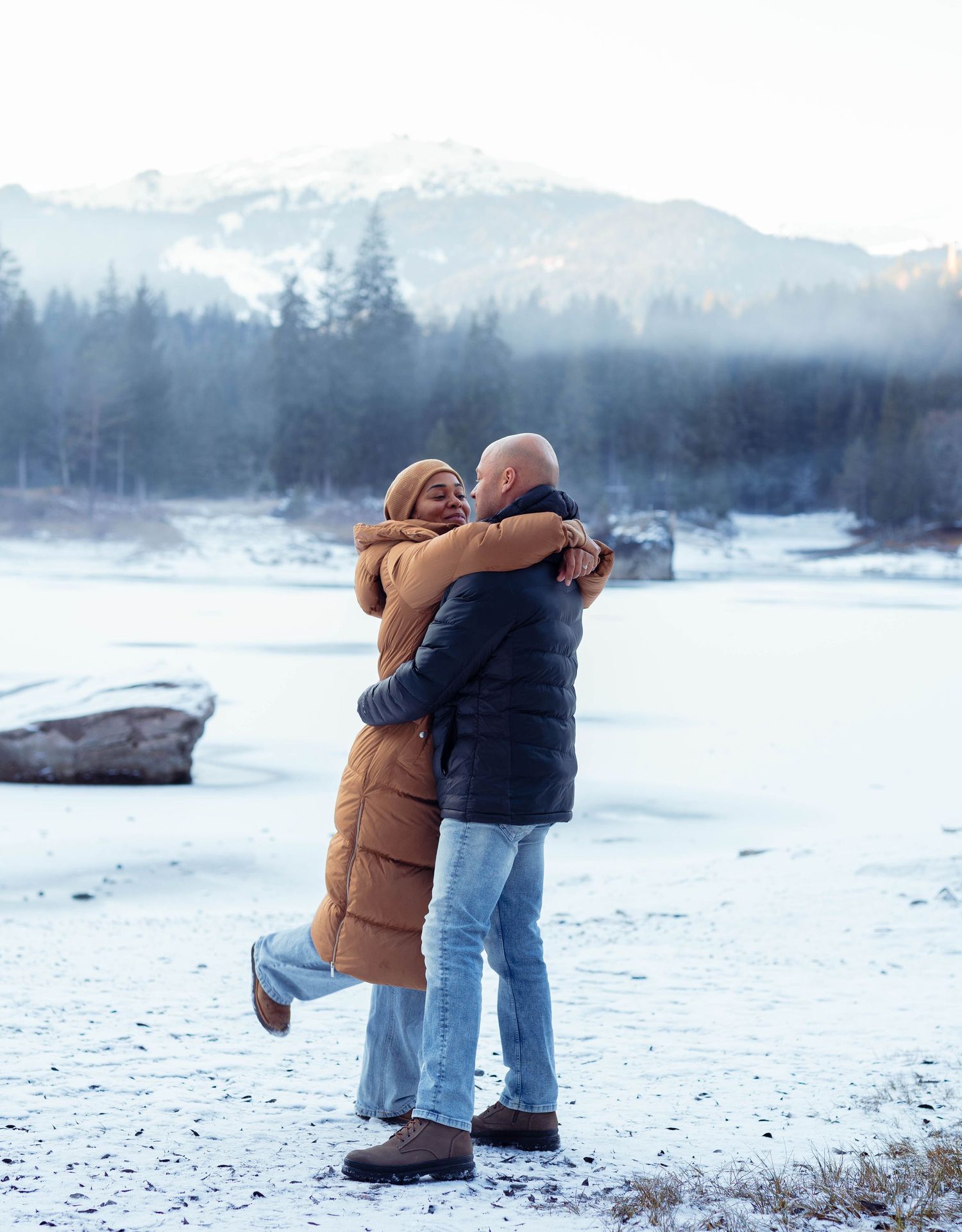 Innige Umarmung eines Paares in der verschneiten Winterlandschaft am Caumasee in Flims.