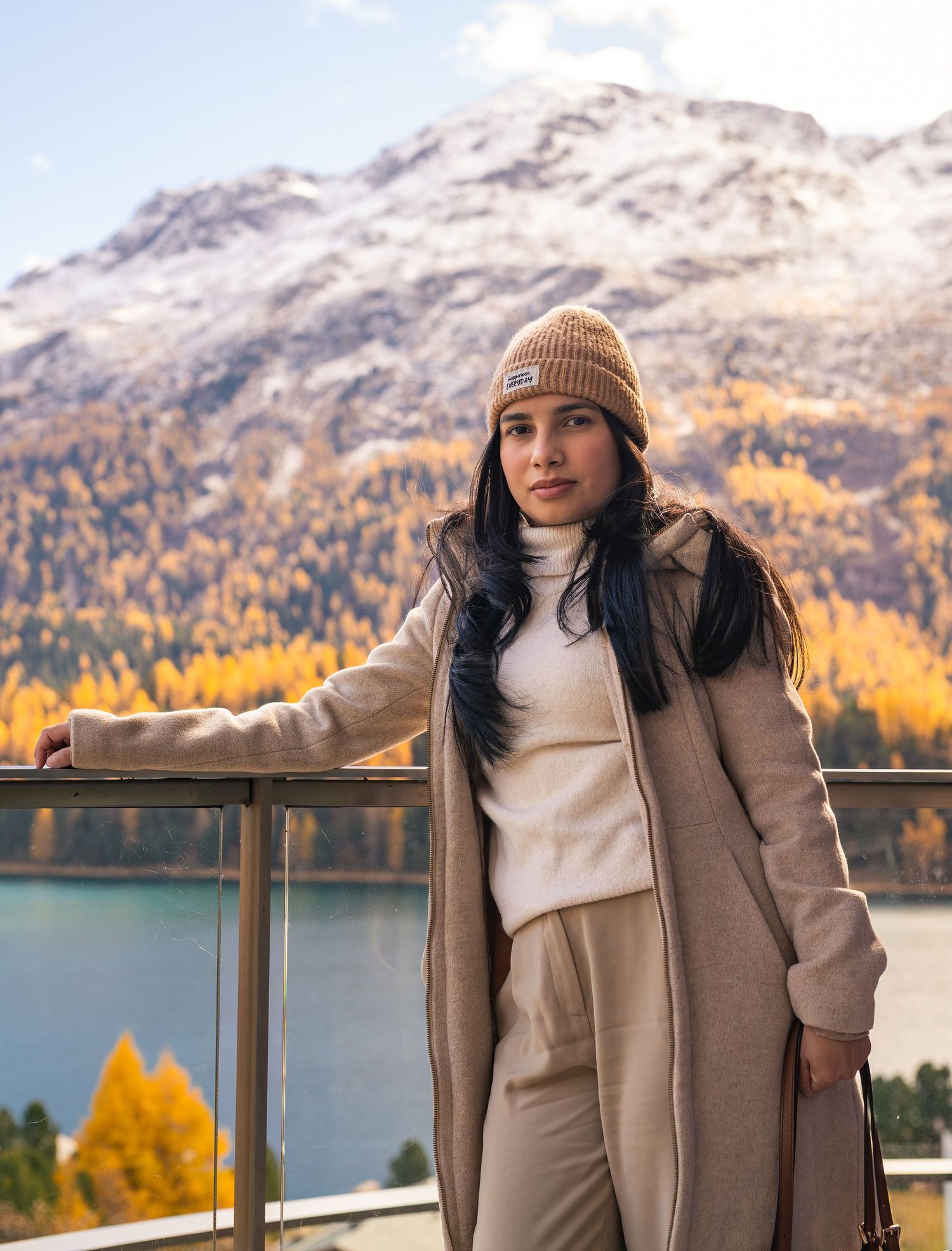 Modisches Portrait einer Frau vor winterlicher Berglandschaft, exklusives Fotoshooting in St. Moritz.
