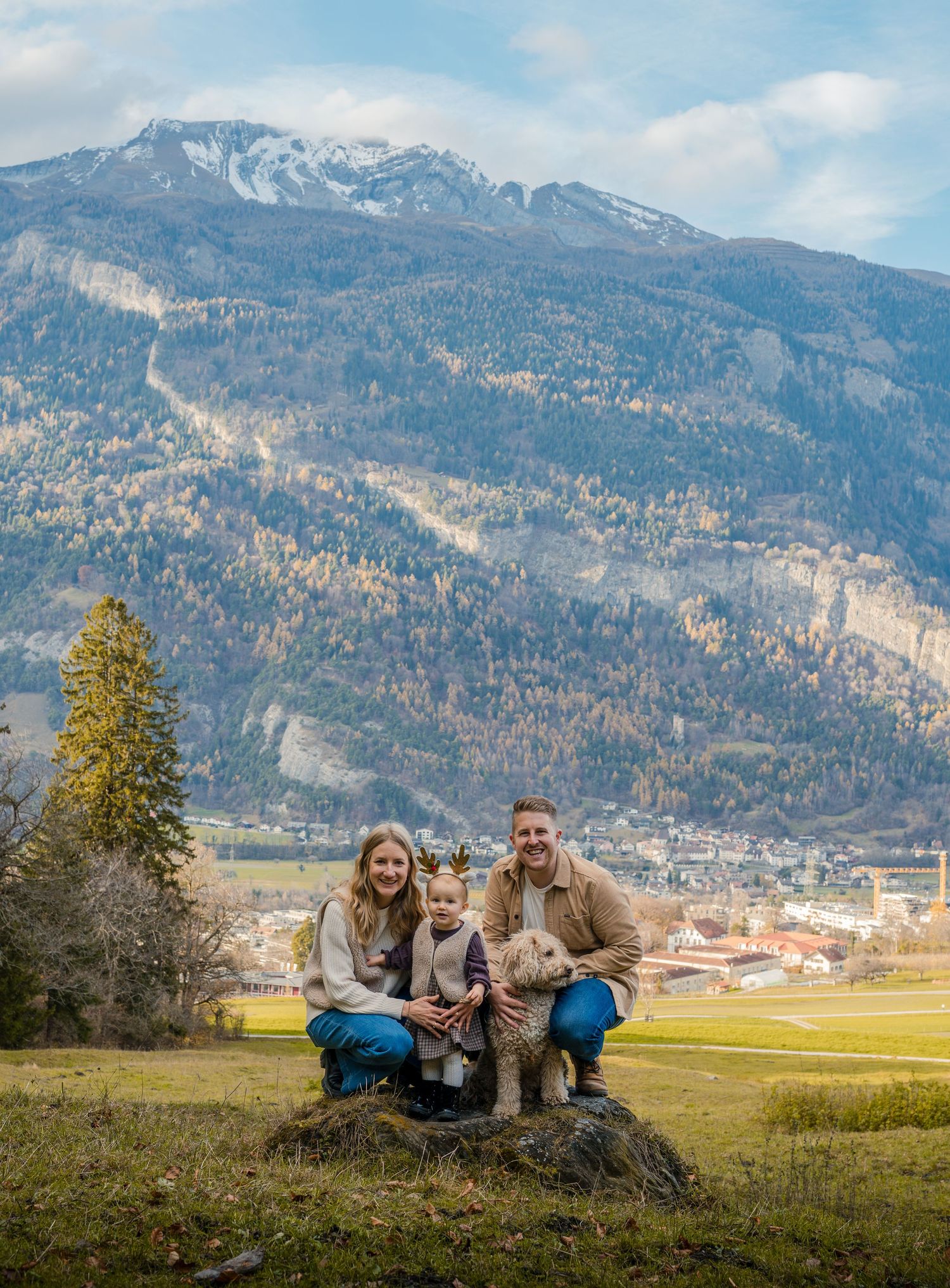 Entspanntes Paar sitzt auf einem Felsen im Tal, Abenteuer-Paarshooting vor epischer Bergkulisse nahe Flims.