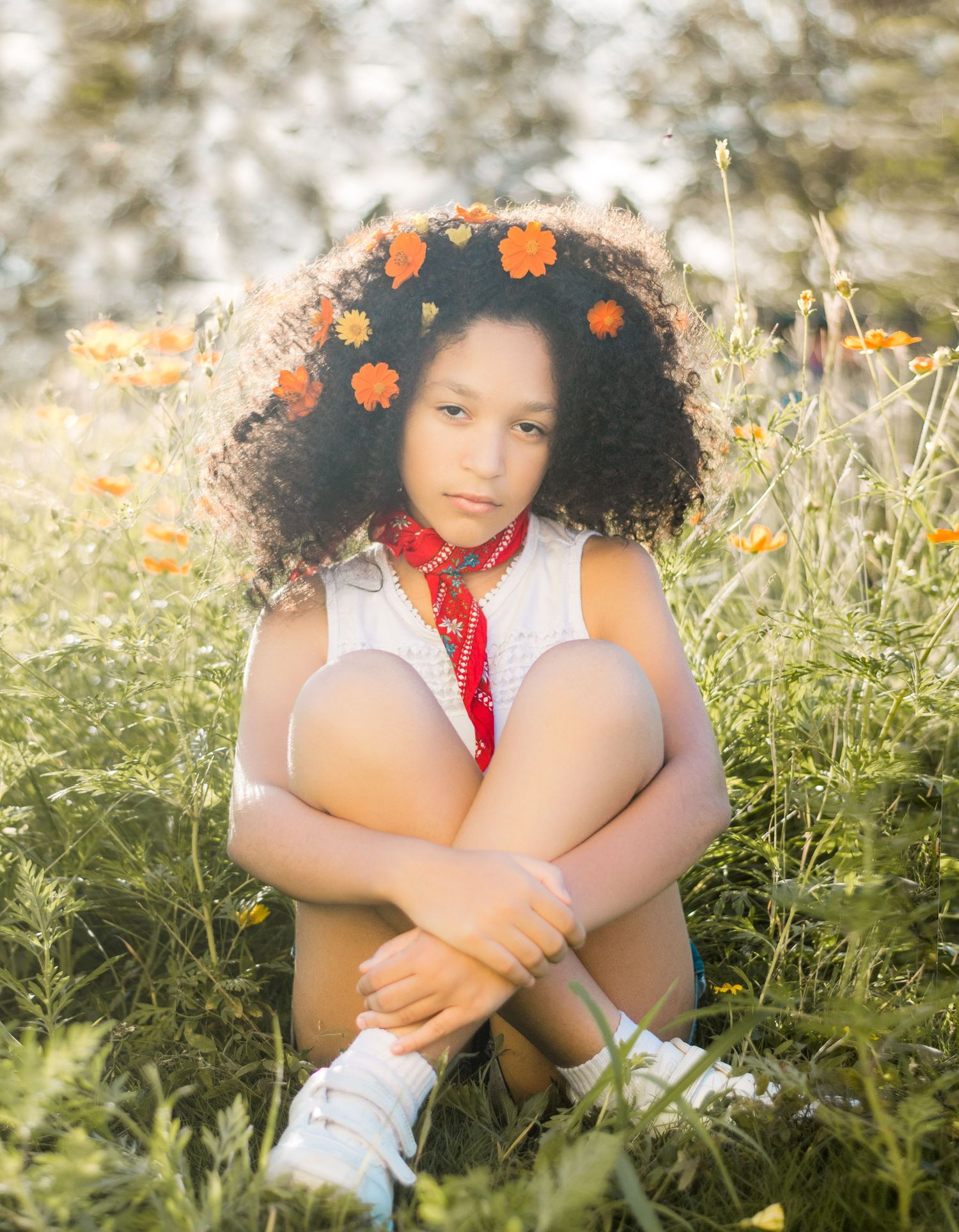 Natürliche Kinderfotografie eines jungen Mädchens mit Blumenkranz auf einer Sommerwiese in Lenzerheide.