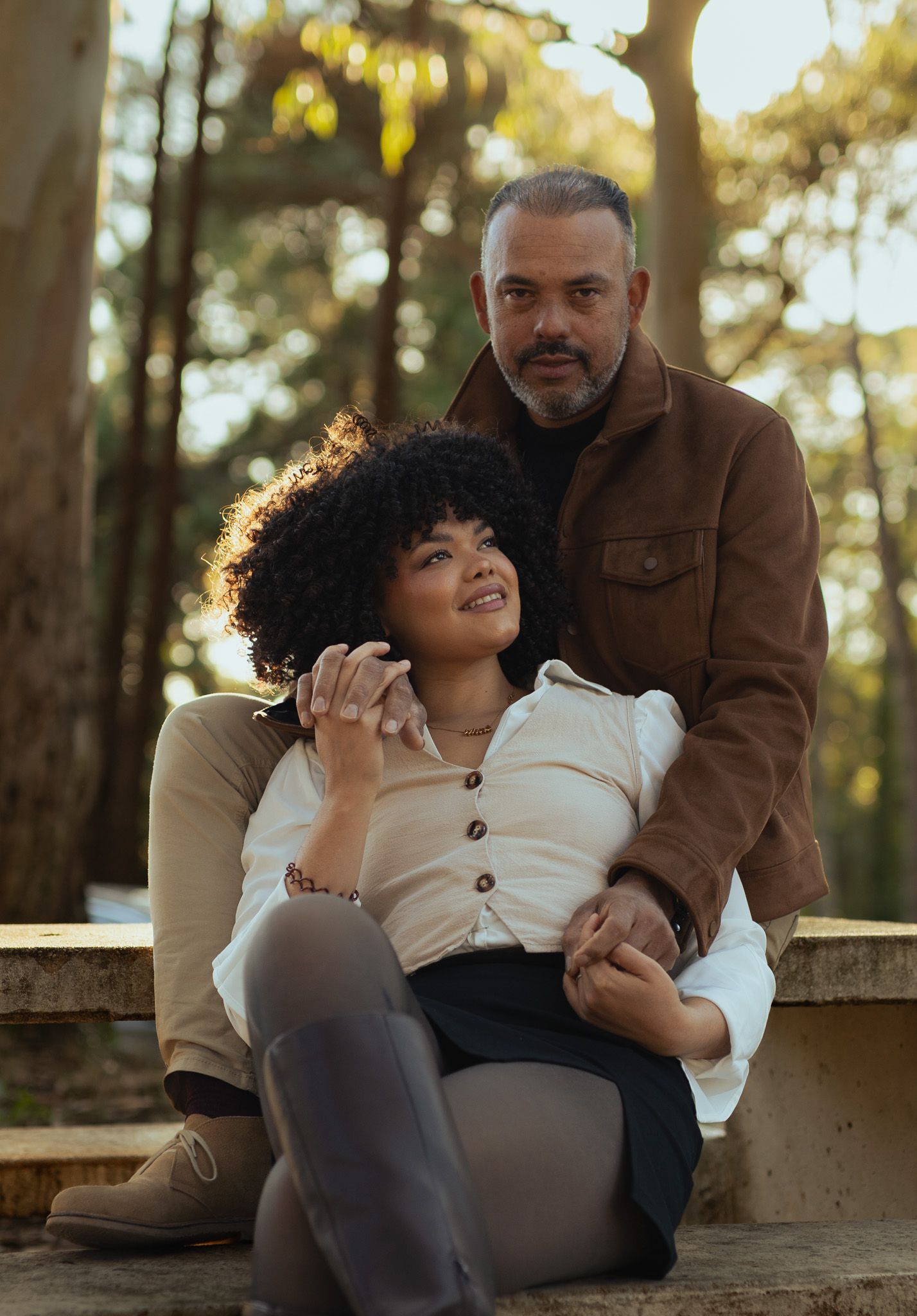 Romantisches Paarportrait im Wald, entspannt sitzendes Paar bei einem Outdoor-Shooting in Arosa.